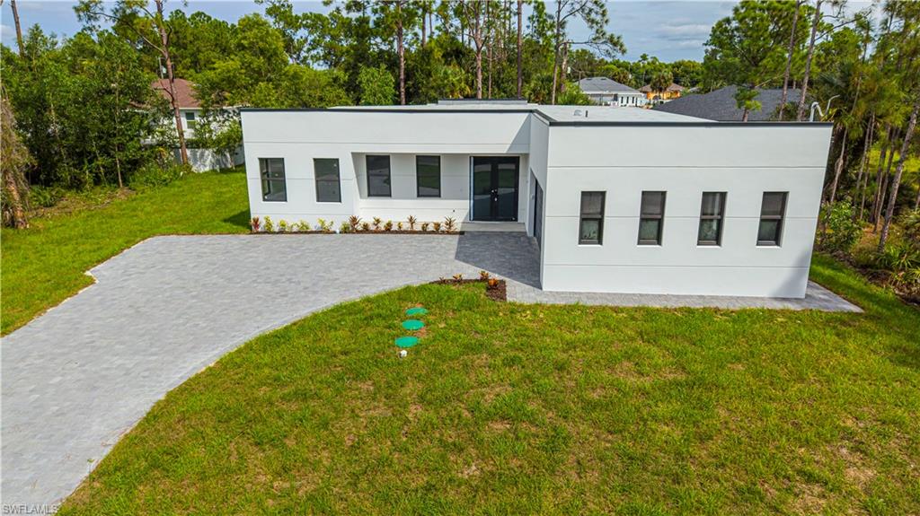 Experience modern luxury in this beautifully designed custom home featuring 3 bedrooms, 2 bathrooms, and a dedicated home office. Showcasing contemporary architecture, clean lines, and thoughtfully selected finishes, this residence combines modern style with everyday functionality.

Step inside to discover a spacious open-concept floor plan featuring high ceilings, large-format tile flooring, recessed lighting, designer light fixtures, and abundant natural light. The kitchen serves as the centerpiece of the home, featuring white shaker-style cabinetry, elegant marble-look countertops and backsplash, stainless steel appliances, a spacious center island, and modern pendant lighting. The adjoining living and dining areas provide an inviting layout for everyday living and entertaining.

The primary suite features large windows, sliding glass doors leading outdoors, and a beautifully appointed bathroom with a freestanding soaking tub, a walk-in shower with rainfall and handheld showerheads, floor-to-ceiling tile, dual sinks, and matte-black fixtures. Two additional bedrooms and a dedicated home office provide flexible living and workspace options.

Additional features include a separate laundry room with built-in cabinetry and utility sink, a reverse osmosis water treatment system, and a two-car garage with finished epoxy flooring.

The exterior showcases contemporary architectural details, black-framed windows, a paver driveway, and attractive landscaping. Surrounded by mature trees and tropical vegetation, the property offers a scenic natural setting and a beautiful backdrop for outdoor enjoyment.

With its distinctive architectural design, open living spaces, and carefully selected finishes, this custom home offers a combination of modern aesthetics and practical comfort. Schedule your private showing today to explore everything this property has to offer.