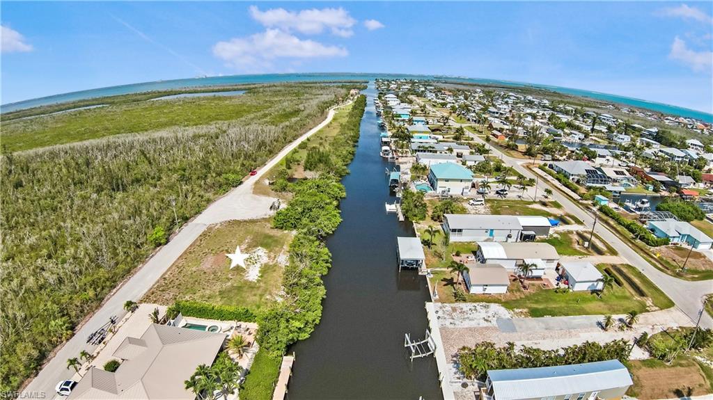 We are proud to present your slice of paradise on Pine Island with this rare gulf-access waterfront lot located in the peaceful boating community of St. James City. This spacious lot offers 110 feet of direct frontage on the Dawson Canal, providing straight-out, unobstructed access to Matlacha Pass and San Carlos Bay—no bridges—just effortless boating to world-class fishing, scenic island hopping, and waterfront dining. The rear of the property is already secured with rip rap shoreline protection along the entire length, providing durability, erosion control, and added peace of mind for your future waterfront build. To make things even easier, the lot has been improved with approximately 100 loads of fill dirt—an estimated $40,000 value—already in place, helping reduce site prep costs and accelerating your timeline to break ground. Tucked near the end of a quiet dead-end road, this homesite enjoys minimal traffic and maximum serenity, surrounded by canal-front homes, tropical palms, and the natural beauty Pine Island is known for. Just minutes away, you'll find local favorites like The Waterfront Restaurant, Low Key Tiki, and Phuzzy's Boat Shack, along with the charming, artsy village of Matlacha, filled with galleries, shops, and island flair. Outdoor enthusiasts will appreciate nearby kayaking trails, birdwatching areas, and nature preserves, while boaters have endless options with direct Gulf access to Sanibel, Captiva, and Cayo Costa. This is a unique opportunity to own a build-ready, rip rap-protected canal lot in one of Southwest Florida’s most laid-back coastal communities. Whether you're planning a full-time residence or a weekend escape, this property offers the perfect gateway to island living at its finest.