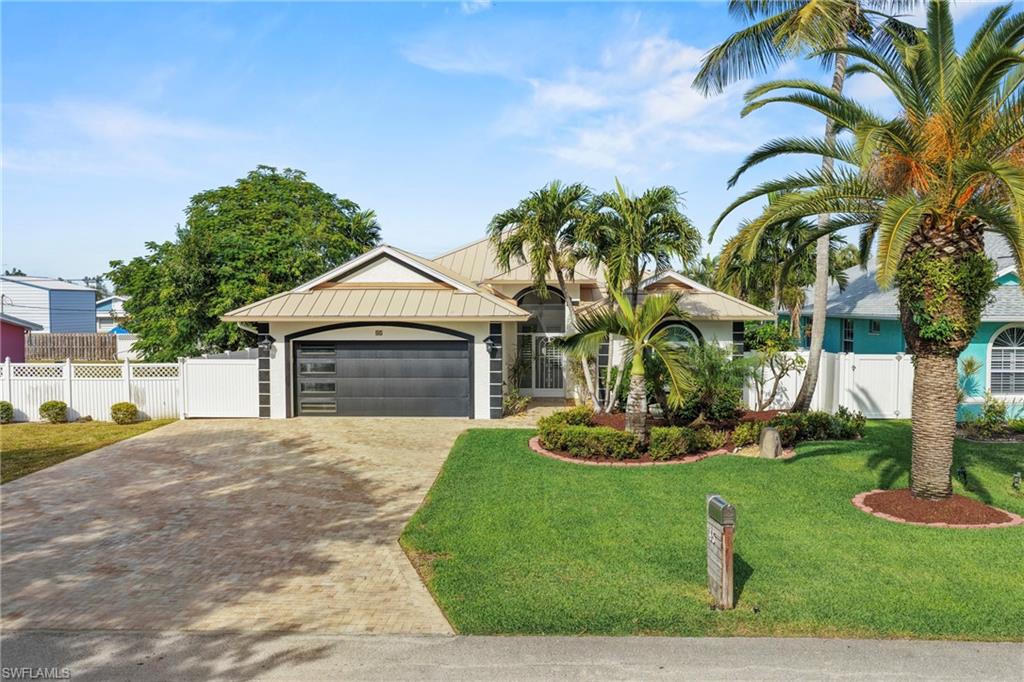 Accepting back up. Welcome to this stunning property in Bonita Shores, nestled in Collier County and just 1.5 miles from beautiful Barefoot Beach. Situated in flood zone X500, this home boasts a higher elevation, eliminating the need for flood insurance. The exterior features a fully fenced, private yard adorned with lush landscaping and a deep well for irrigation. You will have safety and security with a durable metal roof and over $50,000 invested in impact windows and doors, including those for the garage and front entrance. (excludes owners suite slider) The oversized brick driveway, measuring 23 feet wide, provides ample space for parking multiple vehicles. Inside, the bright, open floor plan showcases coffered ceilings and tile flooring throughout. The kitchen is a chef's delight, featuring granite countertops, modern appliances, custom lighting, a decorative tile backsplash, and a pantry for extra storage. Both bathrooms have been tastefully renovated, with the owner's suite bath offering a luxurious soaking tub, roll-in shower and dual sinks. For entertaining, the covered lanai, measuring 29 by 13 feet, is perfect, while the heated pool and spa, added in 2015, come with a remote-operated “Jandy” system. The garage features brand-new epoxy coating, giving it a fresh and polished look. This immaculate home is in excellent condition and ready for immediate occupancy. A prime location offering over a dozen restaurants within walking distance, and as an added perk, you have "deeded boat ramp right" giving you access to the boat ramp on 3rd St., providing direct access to the Gulf. Don’t forget, Collier County homeowners get a free beach sticker. Check out the community clubhouse, where there are plenty of year-round activities such as movie nights, potlucks, book club, dances, dinners, children’s events, fundraisers, and the newly formed “Bonita Well,” which adds even more to the calendar. Bonus, bonus, bonus- You won't be paying any HOA fees in Bonita Shores.