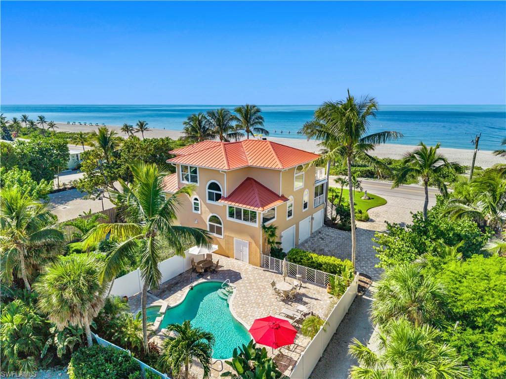 Nestled between the Gulf and Bay, this stunning beachfront home offers unparalleled 180-degree views of both pristine waters, coupled with direct deep-water boating access and a private dock space with lift. Perfect for those who enjoy both the beach and boating lifestyle, this residence seamlessly blends luxurious indoor spaces with expansive outdoor living areas. The thoughtfully designed split floor plan provides ultimate privacy for owners and guests, while the open-concept gathering areas flow effortlessly from room to room. Sunlight pours through large windows, highlighting the voluminous interiors and enhancing the beauty of the home. The light-filled spaces lead to multiple outdoor areas ideal for entertaining or relaxing, all while taking in the spectacular views. Enjoy easy maintenance witha galvalume roof, composite decking, aluminum railings, durable stucco finish, impact windows and doors and more. The beautifully landscaped property boasts a large fenced backyard with pavers, perfect for hosting or enjoying the outdoors, plus a spacious pool and spa for ultimate relaxation. The gourmet kitchen offers fantastic views of the Gulf, stone countertops, a large pantry, a cozy dining area, and an adjacent deck for alfresco dining. The master suite is a true retreat, featuring incredible Gulf views, a spacious bath, two walk-in closets, and a private office. With a 3-car garage, this home is as practical as it is luxurious—making it the perfect waterfront getaway. NOTE, this property is atsome of the highest elevation in the X Zone of Captiva Island.