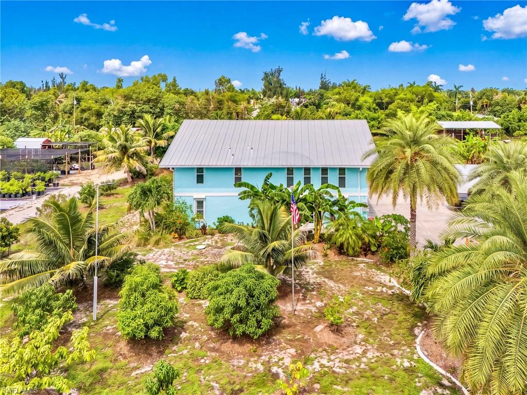 Set on 2.6 acres in Bokeelia, this fully operational tropical island farm is where mornings begin with fresh eggs and evenings end beside the pool in the island breeze. Part home, part orchard and part working farm, it is ready for its next chapter.

Zoned AG-2, the property is ideal for farming, nursery operations or homestead living. The owners currently receive an agricultural tax exemption; the next owner may apply for the same benefit.

The home offers 2,283 square feet plus a 573-square-foot air-conditioned attached garage. Mature trees, nursery inventory, chickens, equipment, tools, furnishings and operational assets are included, allowing the next owner to harvest fruit, gather eggs and grow plants without starting from scratch.

Upstairs are the main living area, kitchen, dining space and primary bedroom, plus a covered porch overlooking the farm. Downstairs are guest bedrooms, a full bathroom, laundry area and second living room opening to the patio and screened pool—ideal for guests or multigenerational living.

Improvements include remodeled kitchen and bathrooms, smart appliances, tile floors, plantation shutters, impact-rated windows and doors, updated A/C, spray-foam insulation, newer water heater and water-treatment systems. A 24-kW generator and 500-gallon underground propane tank add peace of mind. The septic field was replaced, a lift station added, and the roof was resecured in 2022 and inspected annually. The property is not in a designated flood zone.

The grounds produce mango, avocado, coconut, citrus, lychee, starfruit, papaya, jackfruit, passion fruit, moringa and more. Over 100 banana plants representing about 22 varieties are established and producing. App-controlled irrigation reaches about 95% of the trees.

Farm infrastructure includes perimeter fencing, secure chicken coops, three pole barns, two hurricane-strapped sheds and an air-conditioned tool shed with electric service. Nursery supplies and extensive farm equipment are included for continued operation of the on-site market.

Cool off in the screened pool, gather on the lanai or relax on the upper porch in your own tropical oasis. Whether you envision a working farm, nursery, self-sufficient homestead or island retreat with supplemental-income potential, this remarkable property offers room to grow and a lifestyle that feels like a getaway every day.