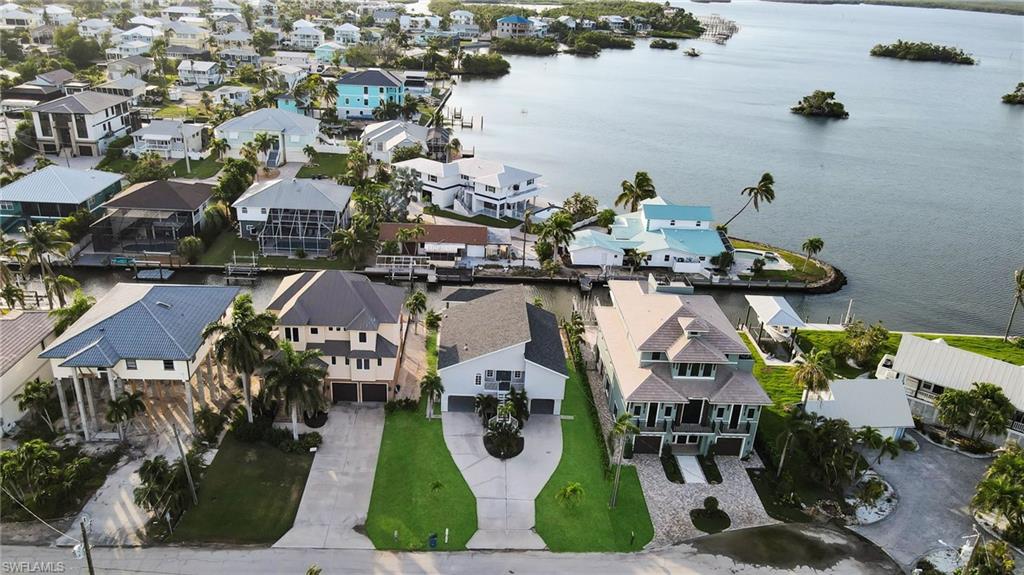 Unmatched waterfront elegance on Fort Myers Beach! This elevated canal estate features direct Gulf access, a private covered boathouse/lift, and captivating views of Estero Bay. The interior offers a split-bedroom layout, vaulted ceilings, and a glassed-in sunroom perfect for dolphin watching. Upgraded with a new roof and A/C, the property boasts a massive backyard garden with room for a luxury pool. Enjoy deeded beach access just steps away, plus close proximity to Margaritaville. Live the ultimate Florida dream.