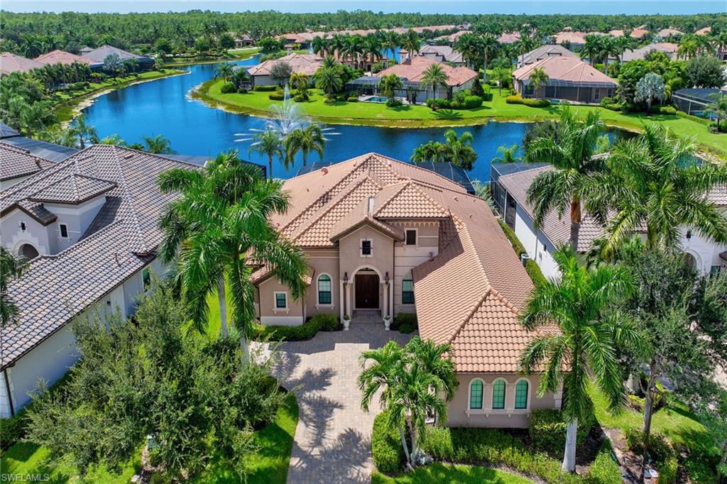 Panoramic southwest lake views create a striking backdrop for this three-bedroom with den and four-bath Greenbriar II floor plan in the guard-gated community of Lakoya at Lely Resort, where expansive indoor-outdoor living, a saltwater pool with spill-over spa and thoughtfully designed outdoor kitchen maximize the waterfront setting. A new HVAC system, three-car garage, multiple en-suite bedrooms, formal dining room and refined architectural detailing further distinguish the home, while its location places downtown Naples and Marco Island within convenient reach. A welcoming foyer opens to the great room, where a double tray ceiling, crown molding and recessed lighting frame the central living space. Four-panel sliding glass doors visually extend the room toward the lanai, pool and lake beyond, bringing the outdoor setting into everyday living. Tile flooring runs throughout the main living areas, while the adjacent den provides a more private retreat with glass French doors, a tray ceiling, white plantation shutters and hardwood flooring. A formal dining room provides an elegant setting for entertaining and special occasions. The kitchen features granite countertops, a tile backsplash, under-cabinet lighting and GE stainless gas cooking appliances, and a 2024 refrigerator. The adjoining eat-in area creates one of the home’s most inviting casual spaces, with built-in bench seating and pool views framed through a seamless panoramic window. Positioned to take advantage of the outdoor setting, the primary suite features pool views through a large window and a glass slider opening directly to the lanai. A tray ceiling and plush carpeting create a comfortable retreat, while two walk-in closets with custom built-ins provide generous storage. The en-suite bath offers separate vanities, a deep soaking tub, a large walk-in shower and mosaic tile accents. Both guest bedrooms include private en-suite baths, one has a tub and the other has a walk-in shower. A separate pool bath with a walk-in shower and linen closet serves the outdoor living area. The lanai is designed as an extension of the home. A generously covered living area features a paver floor and a stained wood-plank inset within the coffered ceiling, complemented by a designer ceiling fan. The outdoor kitchen includes a stainless steel grill and matching hood, prep sink and granite countertop, creating a dedicated space for dining and entertaining beside the pool. Electronic Storm Smart shutters add functionality to the covered area, while the screened pool and spillover spa capture the expansive lake views. Additional features include an air-conditioned three-car garage, recessed lighting, crown molding and thoughtfully integrated architectural details throughout. Within Lely Resort, residents enjoy access to three championship golf courses, plus optional membership opportunities at The Players Club & Spa offering golf, spa, dining and social experiences.