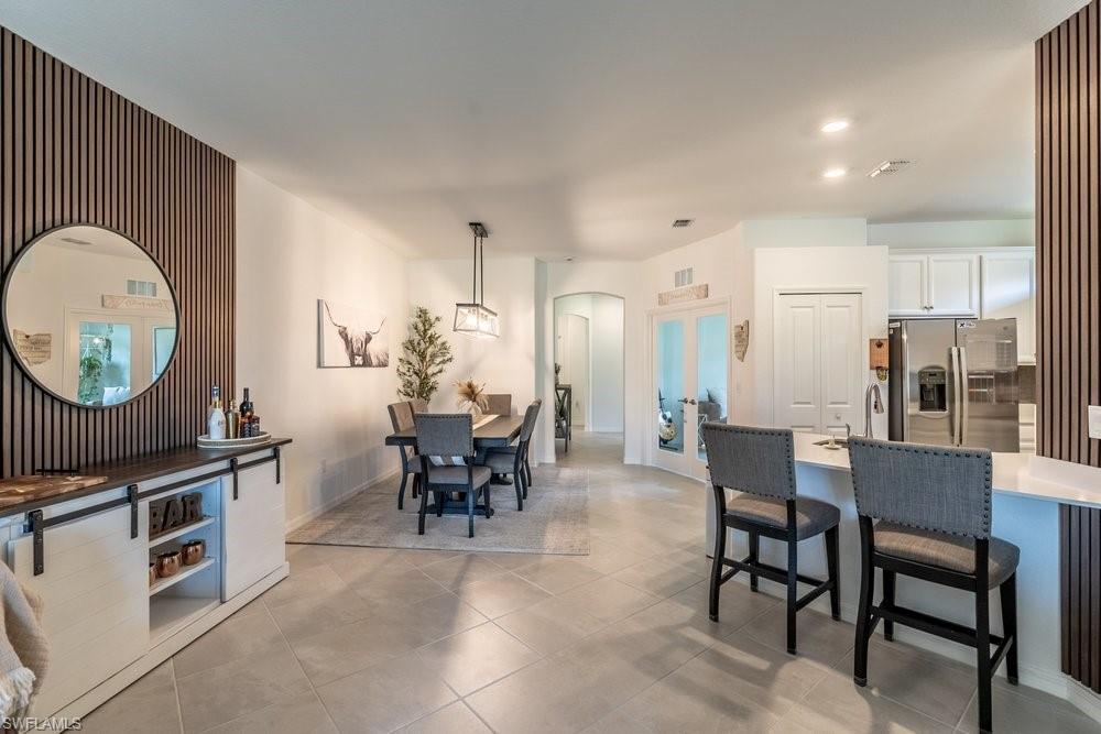 Welcome to 2645 Vine Ave, where effortless Florida living begins the moment you arrive. Offered TURNKEY with an impressive collection of high-end furnishings—including multiple Arhaus sofas and chair—this beautifully appointed 2 bedroom + den, attached villa stands apart from the competition. Simply bring your suitcase, settle in, and start enjoying everything the Naples lifestyle has to offer.

Barely lived in and meticulously maintained in a no-smoking, no-pet home, the residence shows remarkably close to new while offering designer touches and thoughtful upgrades throughout. The bright, open floor plan is complemented by stylish upgraded lighting and ceiling fans, electric roll-down shades, custom closet built-out storage, an epoxied garage floor, and carefully selected furnishings and décor that create a warm, elevated feel throughout the home.

The kitchen opens seamlessly to the dining and living areas, making everyday living and entertaining effortless, while the spacious primary suite provides a relaxing retreat with a beautifully finished bath and customized walk-in closet. A flexible additional living space offers even more room to relax, work, read, or entertain.

Out back, enjoy one of the home's most inviting features: a screened lanai overlooking the water and ideally positioned to capture beautiful Florida sunsets. Whether enjoying morning coffee, an evening glass of wine, or simply unwinding at the end of the day, this peaceful setting makes it easy to embrace indoor-outdoor living year-round. Located in amenity-rich Orange Blossom Ranch, residents enjoy an exceptional resort-style lifestyle with two resort-style pools, a beautifully updated clubhouse, recently renovated fitness center, tennis and pickleball courts, basketball, bocce, playgrounds, parks, and an active community atmosphere. Orange Blossom Ranch also borders the expansive Big Corkscrew Island Regional Park, with future connectivity planned between the community and the park—bringing its sports fields, playgrounds, aquatic facilities, walking areas, and outdoor recreation even closer to home. Everyday convenience is equally impressive, with the new Publix Super Market and restaurants at The Shoppes at Orange Blossom located just outside the community.