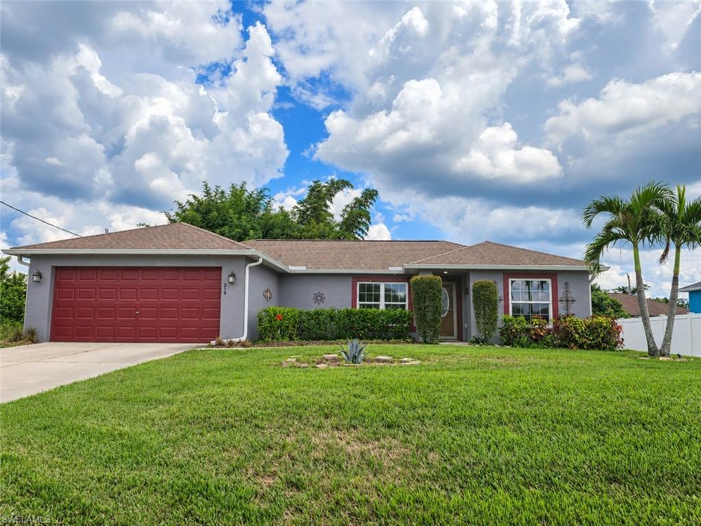 Welcome to 319 Labree Ave S, Lehigh Acres, FL 33974! This open, vaulted-ceiling floor plan features 3 bedrooms, 2 baths, and 1,377 square feet of living space, plus an attached 2-car garage and in-residence laundry room. There are IMPACT WINDOWS, BRAND NEW CARPETING, an irrigation system, 1.5-year-old exterior paint, a 4-YEAR-OLD ROOF, and the home is WIRED FOR A GENERATOR. The bright, open-concept floor plan features vaulted ceilings and an easy flow between the living area, kitchen, and dining space. The kitchen offers generous counter space, a breakfast bar, wood cabinetry, stainless-steel appliances, and a pantry. A split-bedroom layout provides added privacy, while the spacious primary suite includes direct bath access and a walk-in closet. Outside, enjoy a sizable backyard with mature landscaping and plenty of room to create a garden, play area, or future pool. Conveniently situated near shopping, dining, schools, and major roadways, this home presents an excellent opportunity to add your personal finishing touches. The home is unfurnished. SELECT PHOTOS HAVE BEEN VIRTUALLY STAGED OR DIGITALLY ENHANCED. VIRTUAL FURNISHINGS AND DECOR ARE NOT INCLUDED IN THE SALE.