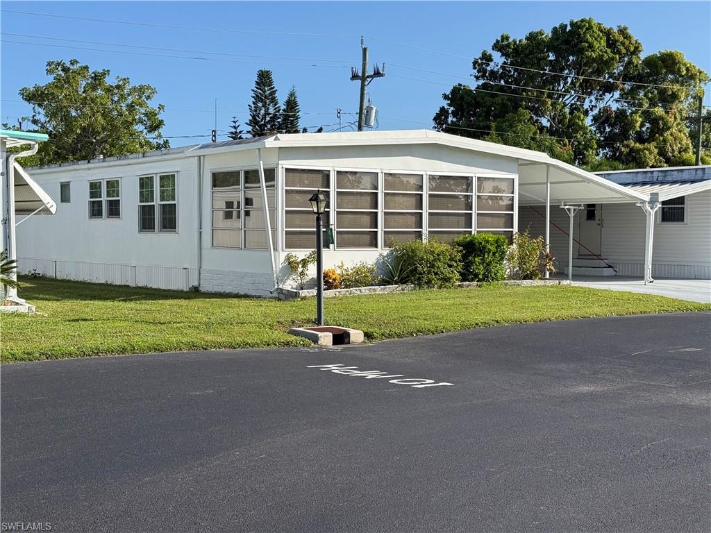 MORE PHOTOS ON THE WAY Welcome to Enchanting Acres, a beautiful 55+ co-op community! This charming mobile home features 1122 square feet of space, making it perfect as a winter retreat or for full-time living. Situated on a beautifully landscaped lot within walking distance of all community amenities, the home includes 2 bedrooms, 2 baths and a carport with space for 2 vehicles. As you approach, you will love the enclosed lanai with plenty of room for relaxation. Inside, you are greeted by a spacious open floor plan featuring tile flooring and updates in the main living spaces, and abundant natural light. The kitchen boasts stainless steel appliances and ample cabinetry. The spacious primary bedroom features a large walk-in closet and an en-suite bath. Additional highlights include a second bedroom and bath, a multi-use den with glass sliding doors, and an outside laundry room equipped with a washer, dryer, water heater with easy accessibility.  Enchanting Acres offers fantastic amenities, including a community pool, shuffleboard, a clubhouse with a kitchen, a billiards room, and a library. It is also located just minutes from downtown Naples, offering easy access to shopping, dining, entertainment, and beaches.