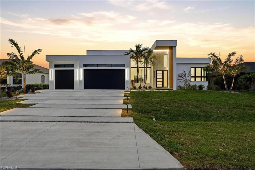 Now designated Flood Zone X, no mandatory flood insurance required! Welcome to 4122 SW 27th Place, an exceptional ultra modern waterfront residence offered fully furnished, blending striking contemporary architecture with refined coastal living. Positioned on a 100 foot wide canal with desirable western exposure, this custom home offers beautiful sunset views and a peaceful setting in one of Southwest Cape Coral’s most desirable neighborhoods.
The home immediately impresses with its bold architectural presence, featuring a dramatic modern facade, flat roof design, expansive glass, and a grand two story entry that fills the interior with natural light. Inside, the open concept layout showcases impressive 14 to 16 foot ceilings in the main living areas, creating a bright and airy atmosphere designed for both comfort and entertaining.
At the heart of the home is a beautifully designed chef’s kitchen anchored by a large statement island with waterfall edges, custom cabinetry, and high end finishes. The space flows seamlessly into the dining and living areas, where a custom entertainment wall with polished concrete finishes, built in cabinetry, and integrated lighting creates a dramatic focal point. Just off the main living space, a stunning glass wine display with adjacent beverage bar adds a sophisticated architectural feature perfect for entertaining.
The residence offers four spacious bedrooms and three full bathrooms. The primary suite is designed as a private retreat, featuring serene views, a generous walk in closet, and a spa inspired bathroom with freestanding soaking tub, oversized glass shower, and elegant modern finishes.
Large sliding glass doors create a seamless indoor/outdoor living experience, opening to an expansive covered lanai with resort style pool and spa, fully equipped outdoor kitchen, and dramatic linear fireplace feature wall overlooking the tranquil canal.
The property sits on a 100 foot wide canal with one bridge and approximately 45 minutes to open water, offering enjoyable boating access while maintaining a calm and protected waterfront environment. The backyard provides a clean waterfront canvas, allowing future owners the opportunity to design and build a custom dock tailored to their boating lifestyle.
Additional highlights include hurricane impact insulated windows and doors, extensive LED lighting throughout, modern architectural finishes, and thoughtful design details that enhance both comfort and visual appeal. Situated on a quiet street ending in a cul-de-sac with only a few neighboring homes, the property offers privacy and minimal traffic while remaining conveniently positioned near shopping, dining, marinas, and entertainment throughout Cape Coral.
