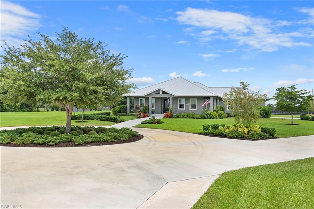 Built in 2023 and set on 2.57 peaceful acres in the country setting of Alva, this exceptional custom home offers the perfect blend of luxury, comfort, and functionality. With 2,761 square feet of living space, the thoughtfully designed floor plan features three spacious en-suite bedrooms, each with its own private bath and walk-in closets, plus a convenient half bath, a versatile den/bonus room/dining room and functional Beach Entry/Family Foyer. The heart of the home is the impressive Chef’s Kitchen, complete with Dual Islands, Quartz countertops, KraftMaid cabinetry, and a walk-in pantry. Luxury vinyl plank flooring flows throughout, while premium upgrades include a METAL ROOF, IMPACT Windows and Doors, R-30 spray foam Insulation, a whole-house Reverse Osmosis system, a high-end hybrid Water Heater, and an attic with pull-down stairs and plywood flooring for additional storage. Step outside to enjoy true Florida living on the expansive covered Lanai featuring tongue and groove Oak ceiling, a fully equipped outdoor Kitchen with bar seating, built-in grill, exhaust vent, sink, and two refrigerator/coolers. The backyard is designed for both relaxation and recreation, with a paver brick walkway and fire pit area, fenced space for children or pets, irrigation supplied by a well, and a utility shed for lawn equipment and protection of the reverse osmosis system. Car enthusiasts, RV owners, and hobbyists will appreciate the INCREDIBLE OUTBUILDINGS. A separate gravel drive leads to a 36’ x 36’ POLE BARN with a concrete floor, perfect for storing an RV, boat, trailers, or additional equipment, along with an adjoining 36’ x 30’ concrete pad.  The incredible 2,400-square-foot INSULATED GARAGE/WORKSHOP is a dream for car enthusiasts, collectors, hobbyists, or anyone needing exceptional workspace and storage. Complete with epoxy floors, electric service, three impact-rated garage doors and windows, and a car lift, it's ready for everything from classic cars to serious projects. Charming curb appeal with circular driveway, side-load 30' deep garage, and peaceful rural setting complete this one-of-a-kind property. Only half mile to N Franklin Boat Ramp. Best of all, no flood insurance is required. If you’re looking for privacy, modern construction, and room for all your toys, this exceptional Alva property is ready to impress. House Plans are available. Check out additional photos in the Tour link.