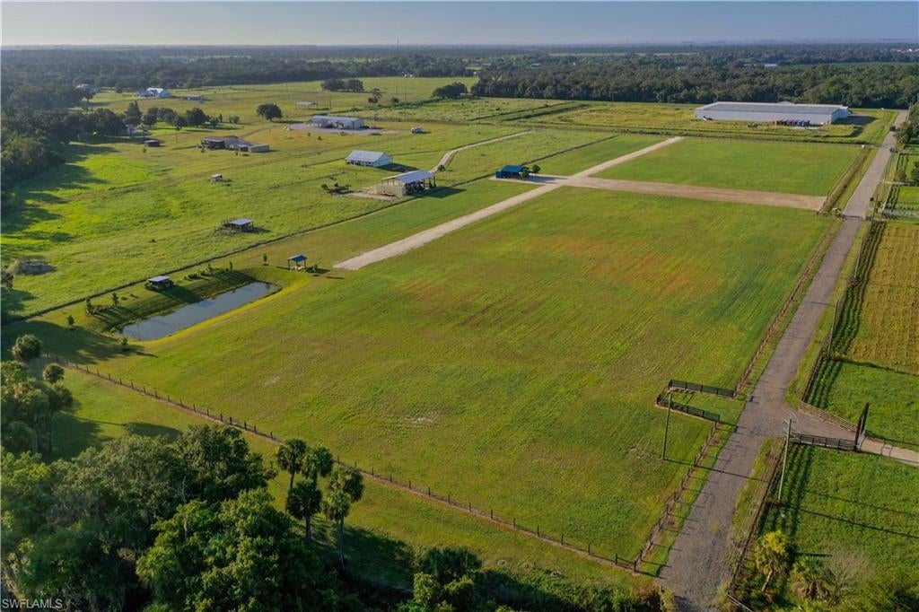 This rare 13.91 acre opportunity is fully fenced, and offers two separate driveway accesses. The land features widespread green pasture throughout, with frontage on Jacks Branch Creek hosting a paver seating area and beautiful native landscaping positioned along the riverbank. Improvements include a 40' storage container attached to a large pole barn, a second small pole barn and a chicken coop, surrounded by beautiful native landscapes. A large stocked pond that can be used for irrigation or fishing. Well suited for a homestead, hobby farm or private estate with Florida's top beaches just an hour away. Contact the listing agent to schedule a showing.
