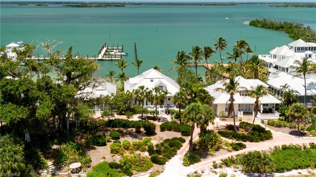 #128 “Twin Shores Cottage” is ideally positioned on the coveted north end of Useppa Island, offering captivating water views to both the east and west from much of the residence. Designed for comfortable island living, the spacious floorplan provides both functionality and privacy, while its elevated setting showcases expansive water views throughout. There is no doubt that “Twin Shores” offers exceptional boating convenience, all within easy reach of Southwest Florida’s most sought-after island destinations.

The main living level features two en-suite guest bedrooms, a full kitchen, and a spacious living area overlooking the Useppa Marina basin to the west. Sunset views extend far beyond the marina basin, with the Intracoastal Waterway and Cayo Costa State Park visible in the distance. The home’s unique twin-water views can be enjoyed throughout the living area, whether looking east toward the sunrise or west toward the sunset. Each guest bedroom also takes full advantage of its positioning, with one offering sunrise water views and the other showcasing sunsets over the water. Adjacent to the kitchen is a multi-sided screened porch that provides a tranquil setting to enjoy morning sunrises over the eastern waters.

Occupying the entirety of the third floor, the Primary Suite offers a private and functional retreat many would envy. The suite features a private balcony with bird’s-eye water views to the west, a private office/den that could serve a variety of additional purposes, ample storage, and a well-appointed en-suite bathroom.

You and your guests will appreciate the independently arranged ground-level apartment, complete with its own en-suite bedroom, full kitchen, living room, screened porch, and laundry room. With separate exterior access from the primary residence, the design creates the opportunity to participate in Useppa’s rental program as a one-bedroom rental unit, potentially helping offset carrying costs without sacrificing the privacy of the main home.

Ownership of “Twin Shores” includes the right to dock a vessel up to 24 feet at the Useppa Marina, conveniently located less than 100 yards from the back door. Also included is a private dock slip with a 10,000-pound boat lift located within a shared dock east of the property, less than 60 yards from the front door. Both forms of dockage are visible from within the home, offering the peace of mind of being able to visually confirm your vessel’s wellbeing at any given time without stepping outside.

Whether welcoming the sunrise or unwinding at sunset, “Twin Shores” captures the essence of waterfront island living from every angle. When investing in island real estate, location, elevation, views, and dockage are paramount. “Twin Shores” possesses all of these qualities with the potential to enhance them even further. Offered furnished with very few exceptions, it presents an opportunity to bring your boat and belongings to commence your newfound island lifestyle.