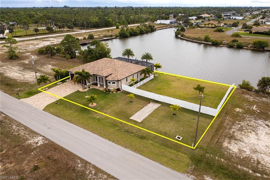 RARE 4-LOT SITE | DIRECT GULF ACCESS (No Bridges) | 10,000 LB BOAT LIFT | TURNKEY FURNISHED Experience Exceptional Waterfront Living in this Stunning, Turnkey-Furnished Direct Gulf Access Pool Home, ideally situated on an Expansive 4-lot Site overlooking a Breathtaking 260-foot-wide Canal with Intersecting Water Views. Offering 3 bedrooms + a den, 3 full bathrooms & a 3-car garage, this property seamlessly blends luxury, comfort & endless possibilities. The exterior showcases double entry doors with decorative impact-resistant glass, a tile roof, paver driveway & lush tropical landscaping. Inside, you are welcomed by a lovely foyer & 10-foot ceilings with elegant tray accents, complemented by tile flooring throughout, impact-resistant windows & doors, attractive furnishings & spectacular water views that carry throughout the home. The inviting great room features a spacious living area with large sliders fitted with electric banded shades, windows adorned with plantation shutters, a den/office with French doors & a dining area overlooking the pool & waterfront—perfect for entertaining or relaxing in style.  The kitchen is truly the heart of the home, offering expansive granite countertops & backsplash, black stainless-steel appliances, an abundance of wood cabinetry & a pantry—both beautiful & functional. The private primary suite is a serene retreat with sliders to the lanai, a mini-split A/C system for enhanced comfort, his & hers walk-in closets & a spa-like bath featuring a soaking tub, walk-around shower & separate vanities. One bedroom has convenient access to the hall bath, while the additional guest bedroom offers an en-suite bath that also serves as a pool bath. There is a separate laundry room with washer, dryer, laundry tub & storage shelves. The 3-Car Garage offers great space with epoxy floors, a large ceiling mounted storage rack & a generator hookup for peace of mind. Step outside to the screened lanai & take in the sweeping wide-canal views. Enjoy the 40-foot long heated saltwater pool & spa with colored LED lighting, deck jets & Southern exposure providing sun on the pool all day. Additional outdoor features include an outdoor kitchen with a beverage refrigerator & propane burner & outdoor shower, creating the ultimate Florida lifestyle setting. Boating enthusiasts will appreciate the composite dock with a 10,000-lb boat lift for relaxing days on the water. This exceptional property also includes a fully buildable ¼-acre lot enclosed by an attractive white vinyl fence, complete with a dog run, sod, sprinklers & a seawall. The additional lot opens the door to endless opportunities—build an RV garage, construct a second home while living in the existing residence, or create your dream outdoor retreat.  The new Crystal Lake Park with a beach, fitness equipment & walking paths is just 1.3 miles away. This is a rare opportunity to own a truly remarkable property that offers luxury, flexibility & the perfect waterfront lifestyle.