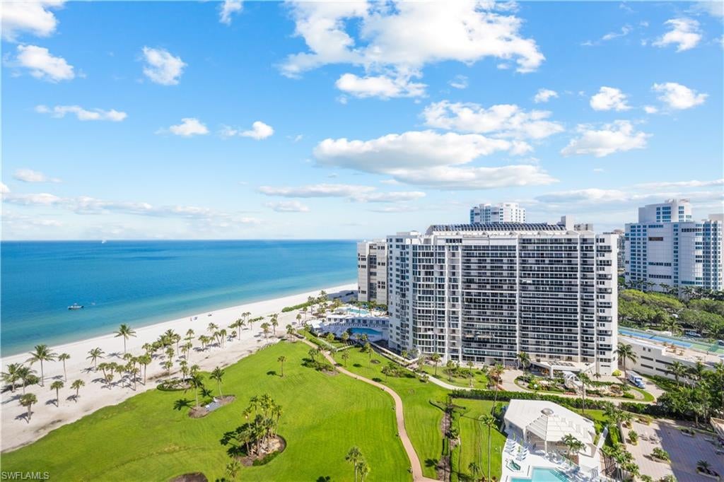 Sophisticated Coastal Living with Breathtaking Gulf and Bay Views:

Beautifully appointed and professionally decorated, this exceptional three-bedroom, three-plus-bath corner residence blends contemporary design, refined comfort, and spectacular coastal vistas. The living room, kitchen, and primary suite enjoy sweeping western views of the Gulf of Mexico, beaches, and parkland, while the guest suites overlook the bay and city to the east.
Thoughtfully renovated throughout, the residence features updated kitchens and baths, sophisticated furnishings, and a serene palette of linen, pale aqua, soft yellow, and cream. Light-filled and inviting, it offers understated luxury with effortless coastal elegance.
The spacious living room includes linen upholstery, leather accent chairs, a marble coffee table, bamboo entertainment console, large flat-screen television, and DVD player. A separate sitting room with four comfortable chairs provides an additional space for conversation or relaxation.
The well-equipped kitchen features handsome cabinetry, upgraded appliances, granite countertops, and a mahogany breakfast bar. The adjacent dining room offers seating for six, a glass-top table with sculptural stone base, beautiful glass artwork, and picturesque beach and Gulf views.
The primary suite offers a king-size bed, luxurious linens, pale aqua accents, a separate sitting area, mahogany desk, large flat-screen television, expansive walk-in closet, and spacious private bath with dual vanities, soaking tub, and separate walk-in shower.
Two elegant guest suites provide queen-size beds, walk-in closets, private baths, and distinctive furnishings. Both open to a private balcony with tranquil bay and city views.
The furnished lanai, appointed with wrought-iron seating, ottoman, and dining table, is ideal for enjoying coastal breezes and beautiful surroundings.
Amenities include ground-level clay tennis courts, a heated swimming pool and spa, and a communal grilling area with covered outdoor seating. Additional guest suites may be reserved through the management office, subject to availability. With its coveted corner location, renovated interiors, generous living spaces, and panoramic Gulf, beach, parkland, bay, and city views, this exceptional residence offers a memorable Naples seasonal retreat where relaxed coastal living meets timeless sophistication. The furnished lanai, appointed with wrought-iron seating, ottoman, and dining table, is ideal for enjoying coastal breezes and breathtaking sunsets.
