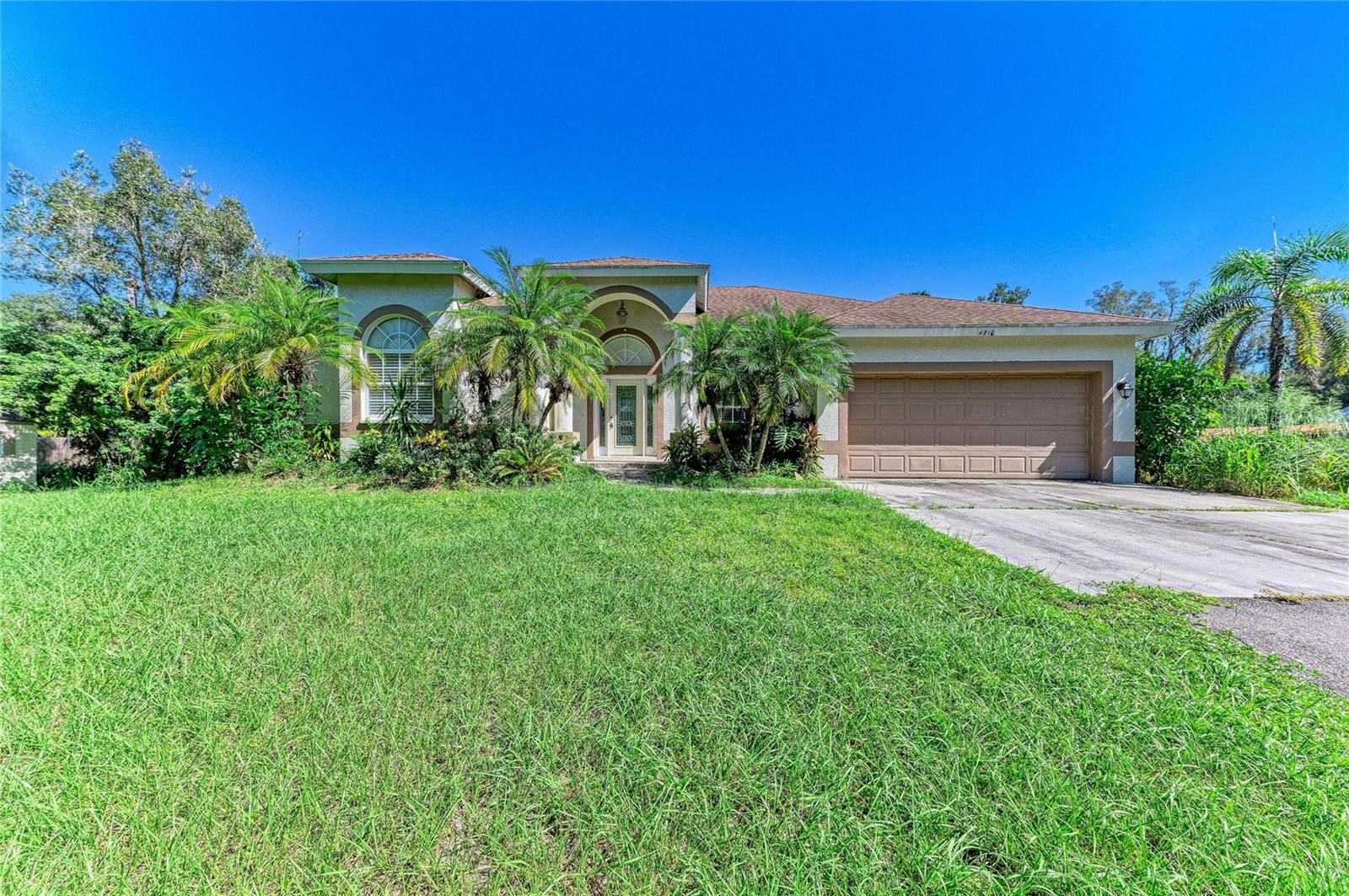 Two homes on 1.46 fenced acres in Sarasota with multiple RV hookups, no HOA, and no deed restrictions, minutes from University Parkway and SRQ.

The main home, built in 2006 of block and stucco, has 3 bedrooms and 2 baths on a split plan: a columned entry foyer, formal dining room, living room, and a great room with a wood-burning fireplace that opens to the kitchen. Tray and vaulted ceilings, tile floors throughout, granite counters, dark wood cabinetry, a closet pantry, and a breakfast bar. The primary suite opens to the lanai and has two walk-in closets, dual vanities, a garden tub, and a separate walk-in shower. Out back, a large screened and paved lanai looks over the lawn.

The detached guest house, built in 2017, is a 1 bedroom, 1 bath with its own entrance, a full kitchen with a granite breakfast bar, and a living area: extended family, a home office, or rental income. An attached 2-car garage, a storage shed, multiple RV hookups around the yard, and a long private drive with room for the boat, trailer and RV. The L-shaped lot runs 150 feet along Brazilnut Avenue, with mature trees on its wooded south leg and a second 97-foot access on 44th Street for trailers and guests. Public water and sewer, flood zone X. Sold as-is.