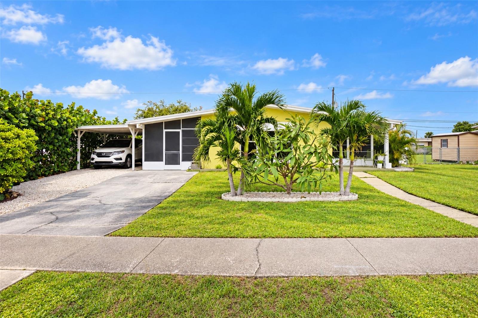 OLD FLORIDA CHARM MEETS MODERN-DAY CONVENIENCE! NO HOA, PUBLIC WATER & SEWER, AND FLOOD ZONE X500!** Welcome to this charming, METICULOUSLY MAINTAINED 2-bedroom, 1-bathroom home offering 897 square feet of living space, where vintage character meets modern conveniences! Exceptionally clean and beautifully cared for, this home is a delightful time capsule featuring gorgeous terrazzo flooring throughout and a timeless Florida feel. From the moment you arrive, you'll appreciate the beautiful curb appeal and covered carport awning providing shade for your vehicle. But the charm doesn't stop inside! Enjoy TWO screened-in patios and a beautifully landscaped backyard surrounded by privacy fencing, creating your own PRIVATE OUTDOOR RETREAT! Perfect for entertaining or simply unwinding, the backyard features a dedicated fire circle area and multiple inviting seating spaces for gathering with friends and family. The property also features TWO STORAGE SHEDS, including a larger shed equipped with ELECTRICITY, offering excellent space for storage, hobbies, or crafts! Major improvements include a METAL ROOF (2022), WATER HEATER (2023), and A/C (2009). Additional highlights include NO HOA, PUBLIC WATER AND SEWER, and FLOOD ZONE X500! Located in the HEART OF PORT CHARLOTTE, you're approximately 2 minutes from US-41, 5–10 minutes from shopping and dining, and less than 5 minutes from TWO hospitals! Whether you're searching for a primary residence, seasonal getaway, or investment opportunity, this home offers the perfect combination of character, privacy, and convenience. **SCHEDULE YOUR PRIVATE SHOWING TODAY!**