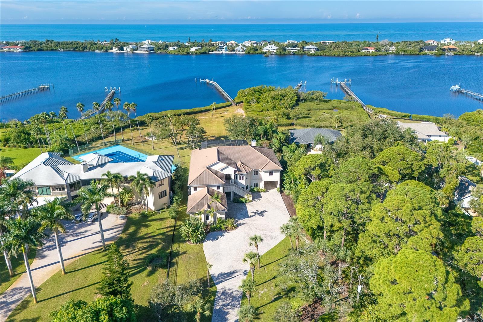 RARELY DOES AN ESTATE OF THIS SCALE, PRIVACY, AND WATERFRONT PRESENCE BECOME AVAILABLE. Set on 1.41 private acres with 175’ of direct frontage on Lemon Bay, elevated approximately 22’ above grade, the main living level captures exceptional Lemon Bay views. This exceptional custom-built residence offers a rare combination of seclusion, craftsmanship, expansive water views, and coveted southwestern rear exposure for spectacular sunsets. This is more than a residence—it is a private coastal sanctuary designed for those who value space, quality, privacy, and the freedom to live exceptionally. From the moment of arrival, the quality is unmistakable, with a paver drive, travertine entry, extensive wood finishes, custom details, and distinctive stained-glass accents throughout. Inside, generous proportions and effortless connections to the water create an inviting sense of luxury. The beautifully appointed kitchen features rich wood cabinetry, center island, built-in pantry, wine storage, premium appliances, and seamless flow into the dinette and family room, where spectacular views of Lemon Bay take center stage. A wood-burning fireplace, dramatic tray ceilings, crown molding, and warm wood flooring add timeless character. The spacious primary suite opens through French doors to a private bay-view balcony, complemented by additional guest accommodations, a dedicated office, and flexible living spaces. Outdoors, a heated saltwater pool and expansive paver lanai overlook the private grounds and Lemon Bay, while a firepit creates an intimate setting for enjoying unforgettable sunsets. The approximately 308-foot dock, with pilings already in place for a future lift, provides an extraordinary opportunity to further enhance the boating lifestyle. Four-car garage capacity plus a two-car tandem underpass, city water and sewer, impact-resistant windows and doors, updated elevated HVAC systems, and a prime location near Manasota Key Beach, marinas, golf, restaurants, and coastal amenities complete this exceptional offering. Opportunities to acquire this combination of acreage, direct Lemon Bay frontage, privacy, craftsmanship, and resort-style outdoor living are exceptionally limited. For the discerning buyer seeking a waterfront estate with presence, personality, and enduring appeal, this is a property that is difficult to replicate. County records show 3BR/2BA , property is a 4BR/2BA/2 half BA’s.