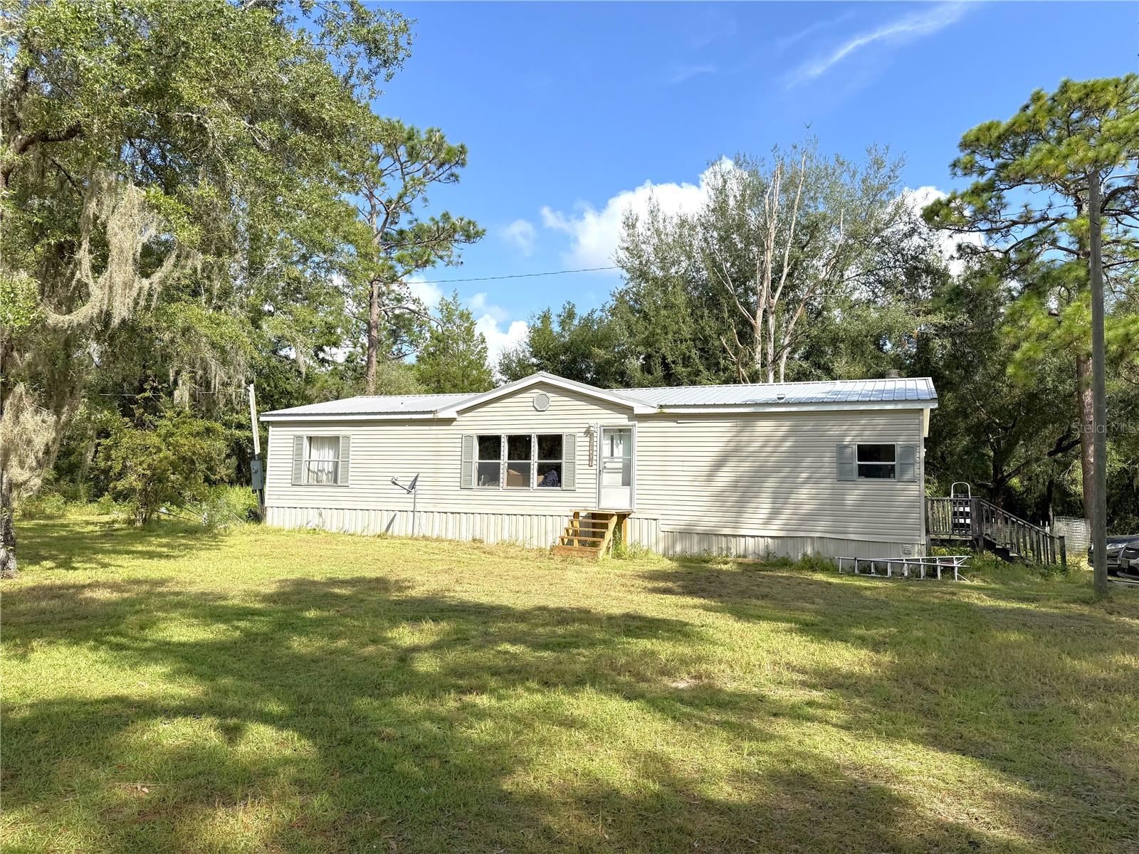 3/2 on 1 ACRE with scattered trees. Start your homestead here in this quiet neighborhood. Split plan with huge Primary Bathroom and Walk-in closet. Wood Fireplace in the Family Room/Dining Room. There are a couple steps leading to the Living Room and Primary Bedroom. 15 minutes to Williston and the NEW Aldi's, Wawa, and Ellianos Coffee, Winn-Dixie, various restaurants and pharmacies. Centrally located between Gainesville, Ocala, Dunnellon and Chiefland.