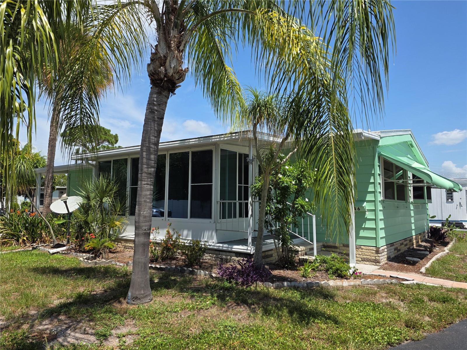 Bring your vision and a little TLC to this spacious 1,032 sq. ft. home situated on a desirable corner lot in the welcoming Oak Grove Mobile Home Park, an active 55+ co-op community.  The home offers a functional floor plan with plenty of potential, plus an enclosed 8' x 15' lanai with tinted glass—an ideal space for relaxing, entertaining, or creating additional living space. Several important updates provide a great head start on your renovation plans, including a membrane roof installed in 2025, newer carport, storage shed, water heater, refrigerator, and newer laminate flooring and subfloors in the main living areas.  Oak Grove offers an impressive array of amenities and activities designed for an active Florida lifestyle. Residents enjoy a heated pool, shuffleboard, bocce, dog-walking area, butterfly garden, and recreation center, along with activities such as bingo, holiday dinners and dances, pancake breakfasts, cards, billiards, cornhole, bocce, and much more.  For beach lovers, Manasota Beach is just 4 miles away, making it easy to enjoy the Gulf Coast lifestyle.  Another standout feature is the affordable $130 monthly fee, which includes lawn maintenance.  With its spacious layout, desirable corner-lot location, 2025 roof, affordable monthly fee, and convenient location near the beach, this home offers an excellent opportunity to create your own Florida getaway in a friendly 55+ community.  Cash-only sale. Bring your ideas and make this home your own!