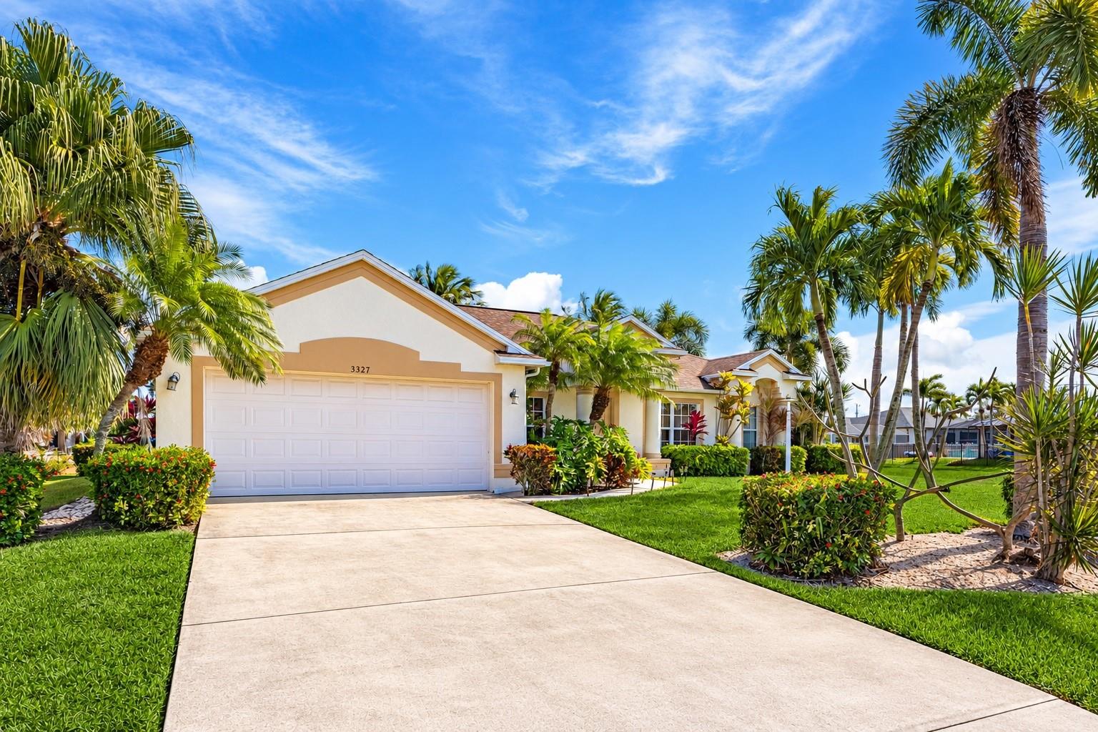 TROPICAL POOL PARADISE IN ONE OF CAPE CORAL'S MOST COVETED NEIGHBORHOODS. Discover this beautifully maintained 4-bedroom, 2-bath single-family home offering an exceptional combination of space, privacy, and the Florida lifestyle! MAJOR 2026 UPGRADES include a BRAND-NEW ROOF, NEW A/C UNIT WITH HURRICANE STRAPS, and an ENTIRELY NEW POOL SYSTEM! Fresh neutral interior paint and new ceramic tile flooring in all bedrooms, the formal dining room, and den/flex space create a refreshed, move-in-ready interior. The spacious, thoughtfully designed floor plan features a formal dining room, eat-in kitchen, and generous den/flex area perfect for a home office, playroom, or additional living space. The kitchen offers stainless steel appliances, abundant cabinetry, a pantry, and convenient breakfast-bar seating. Retreat to the primary suite featuring elegant tray ceilings, a walk-in closet, and French doors opening directly to the pool area. The beautifully appointed en-suite bathroom includes marble flooring, a glass-enclosed tiled shower, soaking tub, dual sinks, and granite vanity. Three additional bedrooms provide comfortable accommodations for family and guests. STEP OUTSIDE INTO YOUR OWN TROPICAL OASIS! Surrounded by gorgeous palm trees, the stunning in-ground pool and expansive paver deck sit within a large screened lanai offering plenty of space for sunbathing, outdoor dining, grilling, and entertaining. Vacant lots directly behind and beside the property provide additional privacy and a peaceful, open setting with fewer neighboring homes. Other highlights include an attached 2-car garage, CITY WATER & SEWER WITH ALL ASSESSMENTS PAID, and a prime SW Cape Coral location offering the perfect balance of tranquility and convenience. With its desirable location, flexible living spaces, extensive updates, and beautiful tropical surroundings, this home offers incredible value at a highly-competitive price. Don't miss your opportunity! Schedule your private showing today!