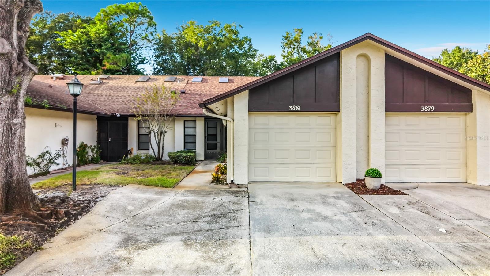 Virtually Staged. Welcome home to 3881 Villa Rose Lane, a charming 2-bedroom, 2-bath single-story townhouse offering 1,083 square feet of comfortable living in Orlando’s 18th Green Villas community. Nestled among mature trees, this home features a roof and A/C both replaced in 2025.
A screened front entry welcomes you inside, where vaulted ceilings and skylights create a bright, airy atmosphere. The kitchen features granite countertops, white cabinetry, stainless steel appliances, and a convenient breakfast bar overlooking the living area, keeping you connected while cooking or entertaining.
The primary bedroom offers a walk-in closet, while granite countertops in both bathrooms provide a coordinated finish. Start your morning with coffee or unwind in the evening on the screened patio, with no direct rear neighbors. An attached one-car garage adds convenient parking and storage.
Located near downtown Orlando and major highways, this villa combines a peaceful setting with convenient access to city life. Come see how 3881 Villa Rose Lane fits your next chapter—schedule your private showing today!