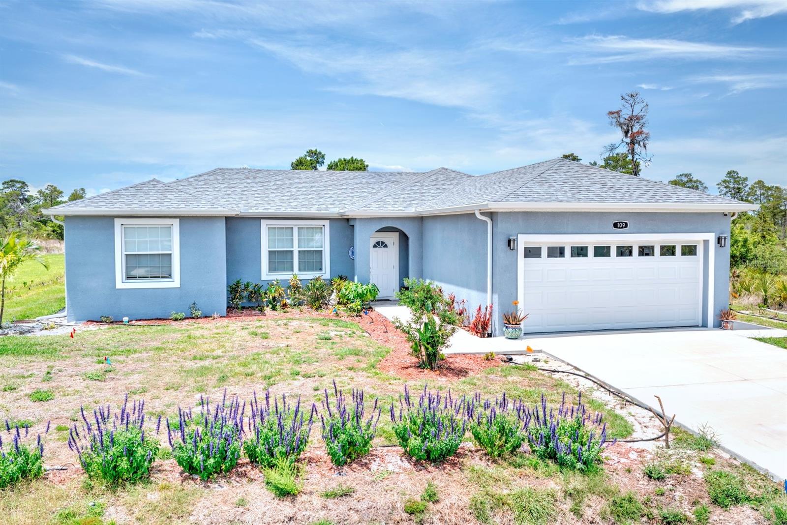 Built in 2023, this modern 3-bedroom, 2-bath home offers a spacious split floor plan with 10-foot ceilings, recessed lighting, vinyl plank flooring, and plenty of natural light throughout. The open living and dining area flows into a stylish kitchen featuring quartz countertops, a large island, stainless steel appliances, ample cabinet space, and a pantry — perfect for everyday living and entertaining. The private primary suite includes dual sinks, a soaking tub, a glass-enclosed walk-in shower, and a custom walk-in closet. Two additional bedrooms and a full bath are located on the opposite side of the home for added privacy. Additional features include a laundry room with storage, a 2-car garage, irrigation for the landscaped yard, and a backyard that can be fully fenced for extra privacy. Located in the peaceful Placid Lakes community, this home is close to shopping, restaurants within the subdivision, and access to Lake June for boating and fishing.