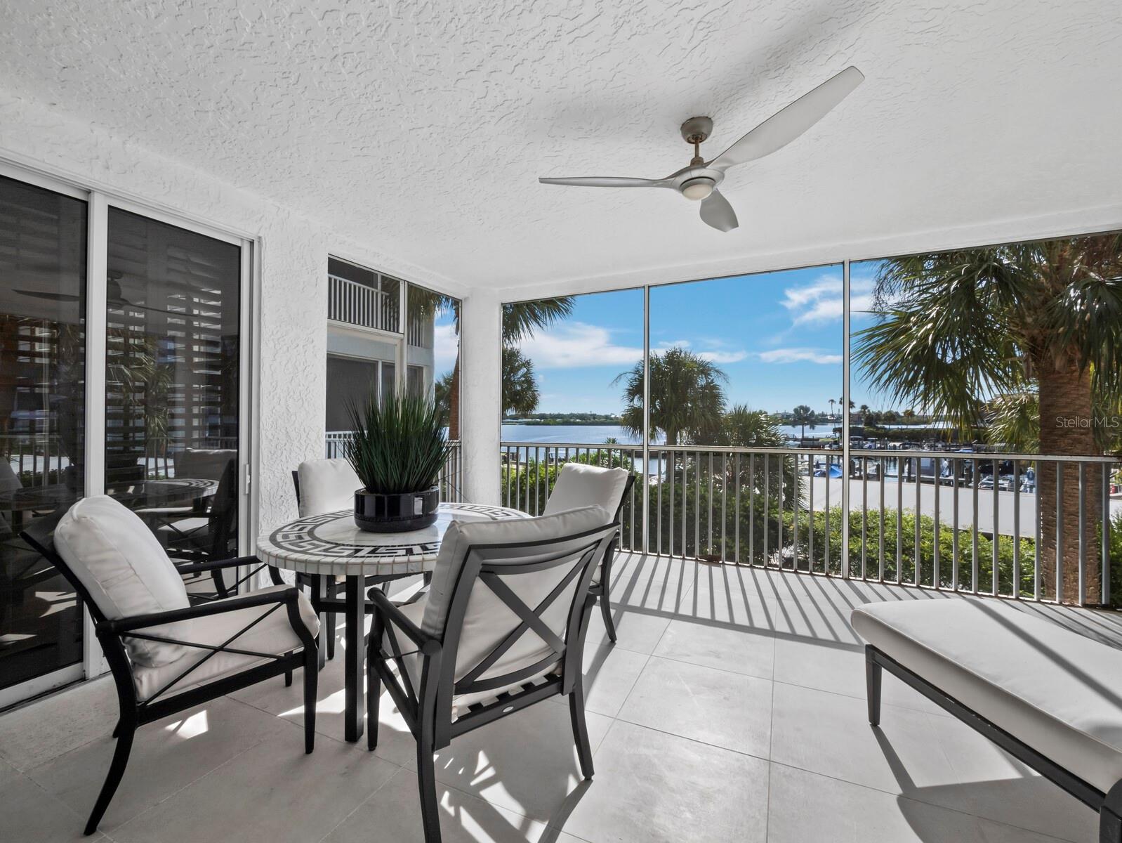 Discover the relaxed elegance of waterfront living at Dolphin Bay, one of Siesta Key’s desirable gated condominium communities. Enjoy beautiful views of Sarasota Bay from this spacious two-bedroom, two-bath residence offering 1,915 square feet of thoughtfully designed living space, complemented by multiple outdoor areas that invite you to embrace the coastal lifestyle. Bright, welcoming interiors feature an expansive living and dining area, a separate family room, and a beautifully refreshed kitchen with white quartz countertops, freshly painted cabinetry and an inviting breakfast bar. A unique and thoughtful feature is the remote-controlled privacy screen that separates the family room from the kitchen, creating a comfortable, temporary guest retreat when needed. This versatile space offers added flexibility for visiting family and friends while preserving the home's open, inviting design. Hard-surface flooring flows throughout, while the split-bedroom floor plan provides privacy and comfort, with both bedrooms featuring en-suite baths. The generous covered rear lanai extends the living space outdoors, offering peaceful views of the tropical grounds and sparkling bay beyond. A covered front terrace and additional sunning deck provide even more opportunities to enjoy Siesta Key's beautiful weather. Additional highlights include a private one-car garage beneath the building, ample guest parking, and a new HVAC system and water heater installed in 2024. Dolphin Bay offers an exceptional combination of waterfront beauty and resort-style amenities, including a clubhouse, swimming pool, spa, tennis courts, fitness center and day dock. This gated, pet-friendly community enjoys a convenient location near Siesta Key's celebrated beaches, with the island trolley just outside the entrance connecting you to the restaurants, shopping and entertainment of Siesta Village. Whether enjoying a quiet morning overlooking the water, entertaining friends or spending the afternoon at the beach, this inviting residence captures the comfort, versatility and effortless enjoyment of the Siesta Key lifestyle.