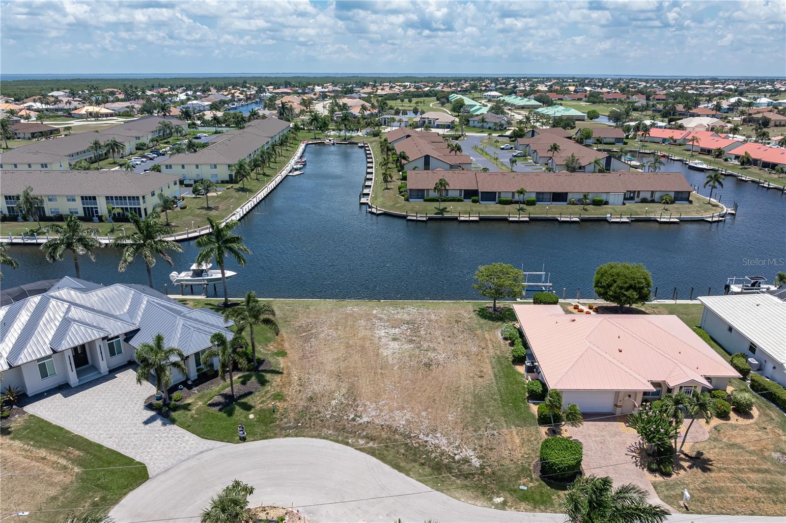SAIL ACCESS, WATERFRONT LOT IN PGI W/110FT OF SEAWALL & SUNSET VIEWS - Build your dream home on this prime waterfront lot in Punta Gorda Isles and start enjoying the boating lifestyle that has made PGI one of Southwest Florida's most sought-after waterfront communities. Not ready to build? Buy and hold as an investment. Located on a quiet cul-de-sac, this sailboat-access lot offers 110 feet of city-maintained seawall, a wide canal view, and quick access to Charlotte Harbor through nearby Buckley's Pass. Prefer a leisurely cruise? Follow the perimeter canal and exit through Ponce Outlet while taking in the scenery along the way. The property measures approximately 87x100x110x120 and provides ample space to design the custom waterfront home you've always envisioned. Western rear exposure delivers colorful sunset views over the canal throughout the year. Picture ending the day on your future lanai as the sky reflects across the water. City water and sewer are available. Located near St. Andrews South Golf Club, you can enjoy a morning on the golf course before setting off by boat for waterfront dining, fishing, or exploring Charlotte Harbor and beyond. Fishermen's Village, downtown Punta Gorda, waterfront parks, restaurants, and shopping are all nearby. An optional membership in the Punta Gorda Isles Civic Association provides opportunities to connect with neighbors and enjoy community events. Keep your boat in your backyard, reach open water in minutes, and start enjoying some of the best boating and fishing Southwest Florida has to offer. Claim your spot in paradise today.