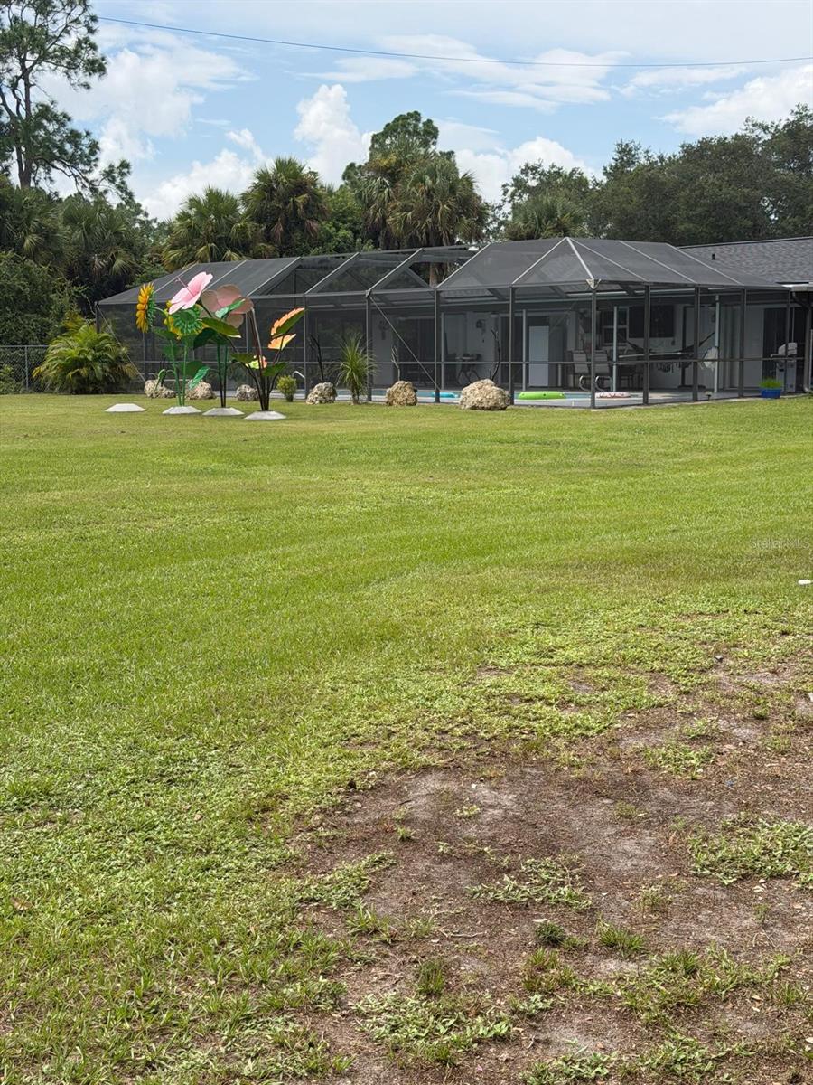 Discover the space, privacy, and versatility this unique Lehigh Acres property Situated on a full 1-acre lot on a quiet dead-end street, this 3-bedroom, 2-bath home features a desirable split-bedroom floor plan, tile flooring throughout, a spacious kitchen with breakfast bar and pantry, and multiple sliding doors opening to the outdoor living area. Enjoy Florida living year-round with a large screened lanai and private heated in-ground pool, perfect for relaxing or entertaining. The property also features impact-resistant windows, hurricane shutters, a fenced yard, and an impressive detached garage/outbuilding with additional covered parking—ideal for vehicles, tools, hobbies, or extra storage. With plenty of outdoor space and no HOA, this property offers a rare combination of comfort, flexibility, and room to enjoy!