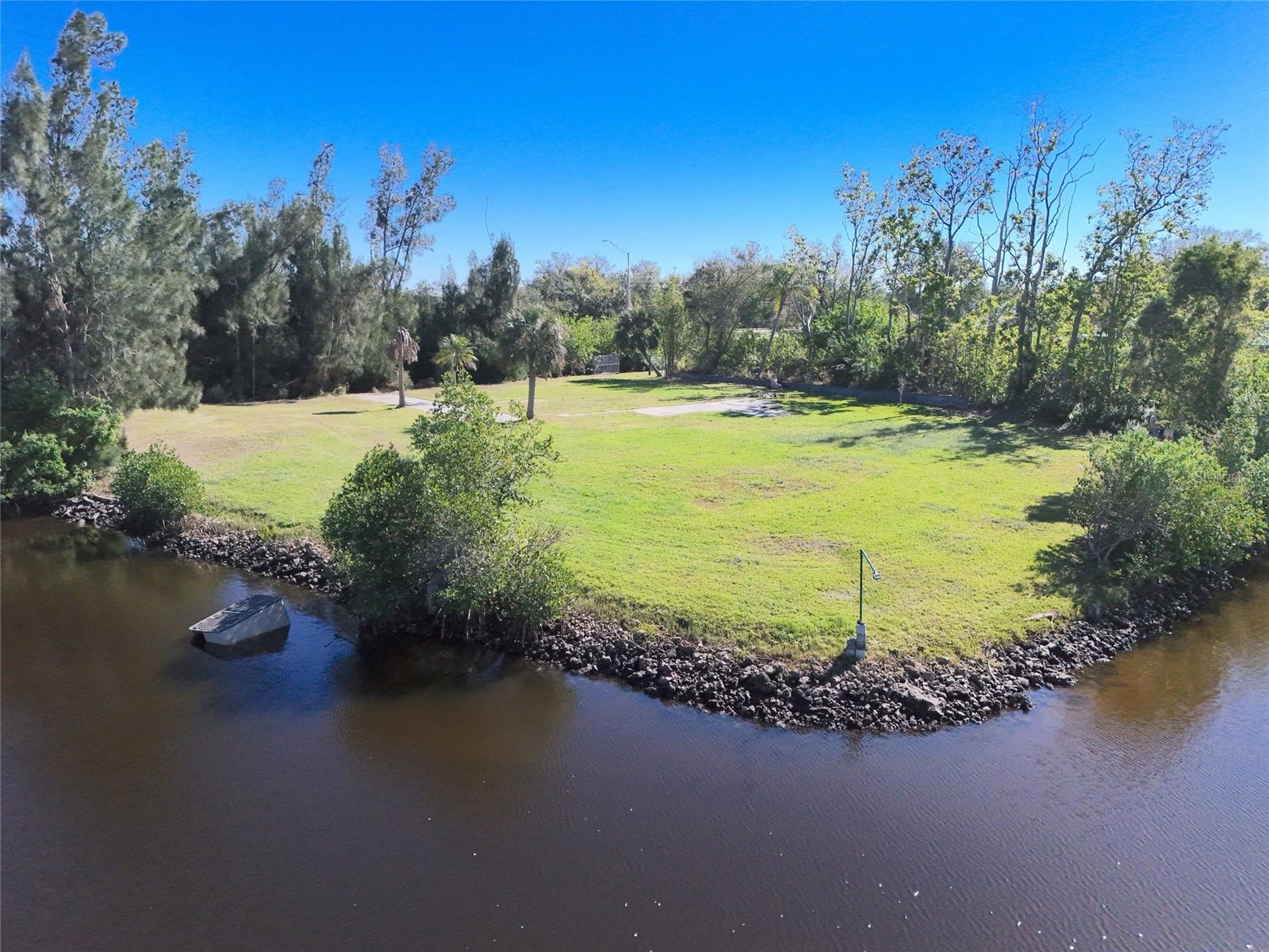 Rare waterfront acreage on Shell Creek — nearly one acre with approximately 180 feet of frontage and lots running up to 235 feet deep from road to water. Three contiguous lots (Sabal Palm Park, Lots 15–17) assembled under one parcel, with building site approval already secured. City water is on-site; buyer to install septic. A recorded plat easement provides clear, unobstructed ingress/egress from the right-of-way to the canal — no access concerns. Zoned MHC: build a conventional single-family home or place a HUD-compliant manufactured home. Shell Creek is one of Southwest Florida’s premier fishing corridors — tarpon, snook, and redfish practically in your backyard — with direct access to Charlotte Harbor and the Gulf. The creek and surrounding preserve are alive with wildlife year-round: manatees, osprey, roseate spoonbills, and more. Minutes to downtown Punta Gorda and the I-75 corridor. Go-and-show — contact listing agent for immediate access.