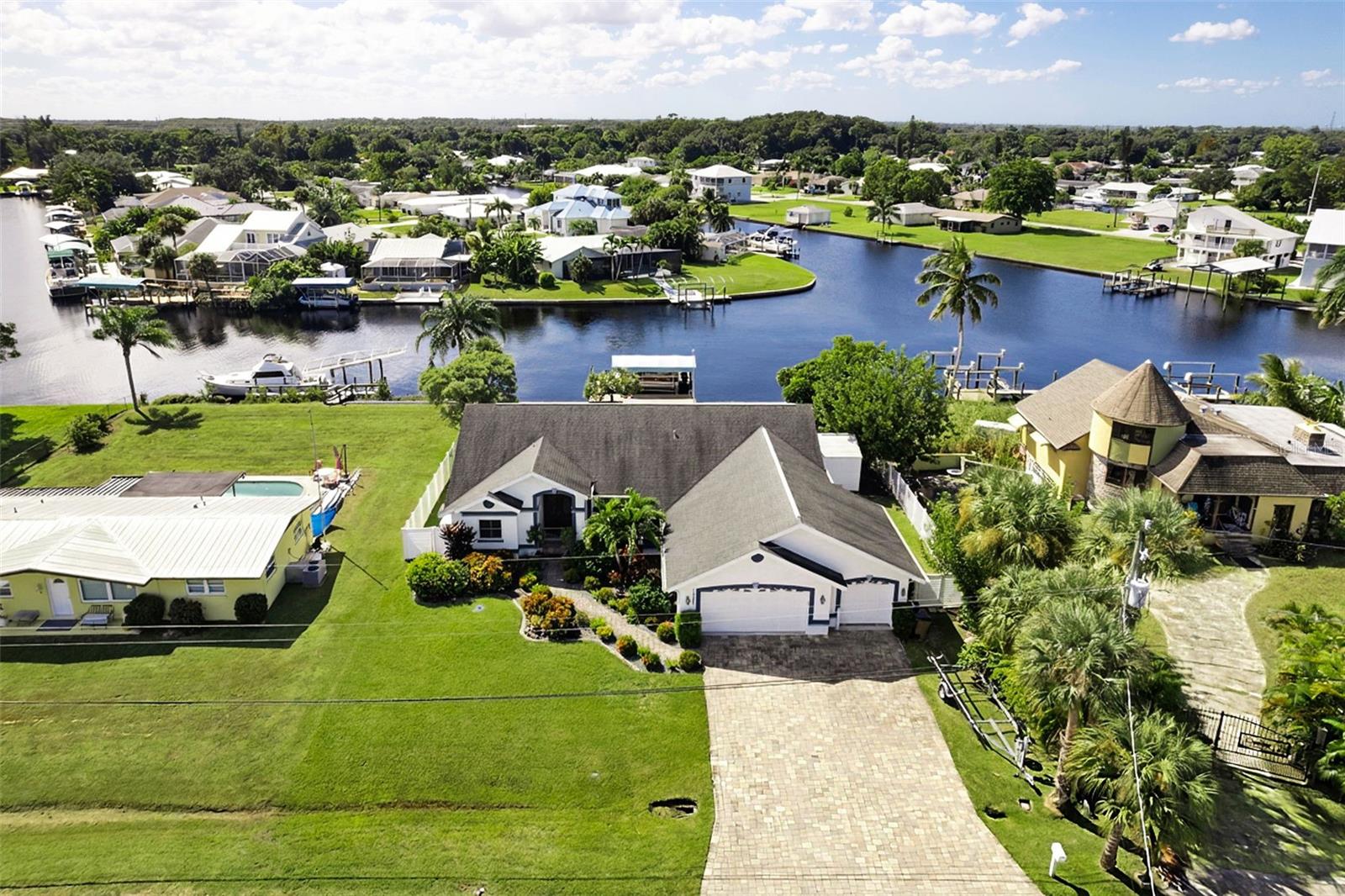 LAID-BACK FORT MYERS WATERFRONT LIVING — WHERE EVERY DAY FEELS LIKE AN ISLAND GETAWAY! SWEEPING INTERSECTING-CANAL VIEWS, DIRECT GULF ACCESS, WRAPAROUND DOCK, 7,500-LB BOAT LIFT, AND OVERSIZED 3-CAR GARAGE!

Some homes offer a water view. This one makes the water part of everyday life. Nestled along wide intersecting canals in Fort Myers Shores, this beautifully updated 3-bedroom, 2½-bath home offers approximately 2,285 square feet of living space and the freedom to embrace Southwest Florida’s boating lifestyle from your own backyard.

Imagine beginning your morning with a latte on the screened lanai as sunlight dances across the water. Keep an eye out for a passing dolphin or manatee—you never know what nature may have in store! When the mood strikes, step aboard your boat from the private wraparound composite dock, lower it from the 7,500-pound lift, and cruise toward the nearby Caloosahatchee River and Intracoastal Waterway, with the Gulf beyond. Need fuel? CTen Marina is approximately one mile upriver, while The Boathouse Restaurant is approximately one mile downriver for delicious waterfront dining. Whether fishing, cruising, or exploring, adventure begins at home.

Inside, natural light and beautiful water views welcome you into a floor plan featuring a formal living room with an elegant tray ceiling, separate dining room, and spacious kitchen opening to the family room. Granite countertops, upgraded cabinetry, stainless-steel appliances, a highly desirable gas range, and generous island make entertaining a pleasure. Plantation shutters, volume ceilings, and sliding glass doors to the lanai complete the relaxed Florida atmosphere.

The spacious primary suite opens to the lanai and features a walk-in closet and private bath with dual vanities and a separate shower. Two additional bedrooms welcome family and guests, while a lanai-accessible half bath adds convenience.

Outside, the fenced backyard invites you to relax beside the water, gather around the firepit, or simply enjoy doing absolutely nothing at all. There’s even the possibility of adding a private swimming pool, subject to applicable setbacks, permitting, and approvals. Imagine your own little waterfront paradise!

Improvements include a 2018 roof, 2023 A/C, upgraded kitchen and bathroom cabinetry, 2023 kitchen reverse-osmosis filtration, 2024 vinyl fence, hurricane-impact windows, 2025 Storm Smart flood barrier system, and 2025 camera and security system. Well-fed landscape irrigation avoids using metered household water for watering. A 2022 boat lift canopy, generator, safe, and appliances are included. The oversized three-car garage offers plenty of room for vehicles, boating gear, and storage.

Although leaving your waterfront retreat may be difficult, downtown Fort Myers offers historic charm, wonderful restaurants, shopping, and entertainment. And when the Gulf calls, Fort Myers Beach awaits with sugary sand, waterfront dining, and spectacular sunsets.

As afternoon slips into evening, pour a margarita, piña colada, or your favorite little umbrella drink and settle in beside the water as the sky softens into shades of gold and coral. Watch the boats return, enjoy the Florida breeze, and savor having nowhere else you need to be. It’s time to stop dreaming and start making your Southwest Florida Sunshine Days an amazing reality!
