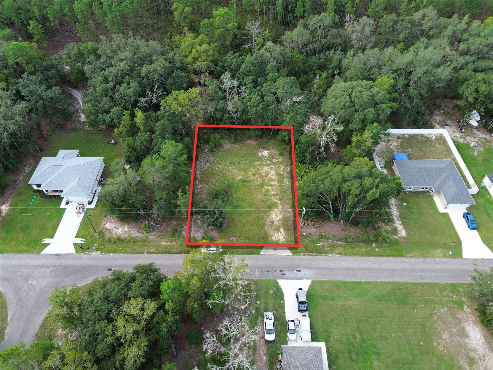 This approximately 0.23-acre residential lot offers about 80' of frontage by 126' of depth. The property was previously improved with a residence, which has since been removed, leaving an open homesite area with an existing driveway/apron visible at the road frontage.
The property is zoned R-1 for single-family residential construction and is located in Flood Zone X, indicating minimal flood risk. The lot sits on a paved road in an established residential area with surrounding homes. Duke Energy is the area electric provider, with power lines located along the road frontage. The property previously contained a residence; buyer to verify the existence, condition, and usability of any existing well or septic improvements. Enjoy convenient access to Lake Weir, Carney Island Recreation & Conservation Area with public boat ramps, and the Ocklawaha River, offering opportunities for boating, fishing, swimming, kayaking, hiking, and other outdoor recreation. Parcel ID: 9038-1239-09