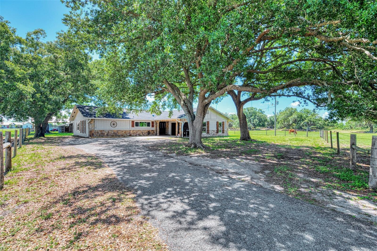 DON'T MISS THIS ONE!! BRING YOUR FARM ANIMALS, TOYS, AND FURNITURE!! This stunning modern farmhouse on over 10 acres is everything you’ve been waiting for!! Located in one of the most desirable areas of DeSoto County, this beautifully updated 4-bedroom, 2-bath home perfectly blends rustic farmhouse charm with stylish modern finishes. Inside, you’ll find shiplap accents, exposed beams, and sliding barn doors paired with granite countertops, stainless steel appliances, subway tile, and thoughtfully designed living spaces throughout.  This property is loaded with upgrades and features for peace of mind living including a NEW ROOF in 2023, newer HURRICANE IMPACT WINDOWS (2020), newer septic system (2017), an updated two-zone A/C system with new ductwork, a huge bonus room, an oversized two-car garage, workshop space, a BRAND NEW POLE BARN, and so much more!! The paved driveway and automatic gated entrance add convenience and privacy from the moment you arrive. If you love the outdoors or want to try your hand at farming, you will love the impressive outbuildings, including a large barn with covered storage for ATVs, boats, or equipment, plus enclosed workshop/man cave space, hay storage, and even a chicken coop!!  The property is fully equipped for country living with both a traditional deep well for the home and an artesian well for livestock watering. Add a garden and create your own private, self-sustaining retreat!! Backing up to the beautiful RV Griffin Reserve and situated at the end of the street with minimal traffic, this peaceful property offers privacy, scenic views, and a small creek running through the land — perfect for HORSES or CATTLE!! Rarely does a property combine modern updates, functional acreage, and farmhouse character quite like this one.  And it's ideally located (NOT IN A FLOOD ZONE!!) close enough to shops, restaurants, golfing, and HISTORIC DOWNTOWN ARCADIA, yet far enough to get away from it all!!  Call today to schedule your private tour!!