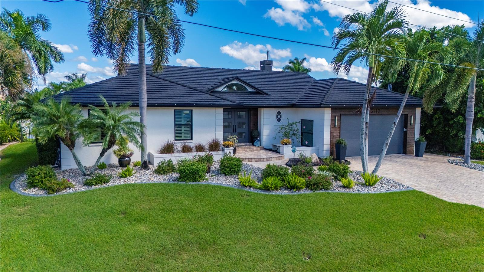 This exceptional waterfront residence in prestigious Punta Gorda Isles blends refined design with modern sophistication, offering an elevated coastal lifestyle on a serene canal with a wide basin/lake view that feels truly rare. With 3 bedrooms, 2.5 baths, and 2,535 sq ft, this home has been transformed with high-end upgrades throughout, every detail curated for beauty, comfort, and performance. A dramatic entry welcomes you into expansive living and dining spaces enhanced by vaulted ceilings, architectural lines, and a striking fireplace that anchors the room with timeless elegance. The gourmet kitchen is a showpiece, featuring premium Italian cabinetry with pull-out drawers, sleek design, and granite and quartz countertops carried throughout the home for a cohesive luxury aesthetic. An elegant bar area with a wine refrigerator and custom cabinetry adds a refined touch, perfect for entertaining and enhancing the home's upscale ambiance. A standout feature is the large, multifunctional laundry room, thoughtfully designed to include a prep kitchen/office space, ideal for entertaining, catering, hobbies, or remote work. This flexible area elevates the home's functionality while maintaining its premium feel. The outdoor living experience is resort-style and unforgettable. A fully enclosed saltwater pool with heater invites year-round enjoyment, framed by travertine wall accents on the lanai that create a warm, Mediterranean ambiance. The exterior is equipped with hurricane shutters, while the interior features plantation shutters and roll-down blinds, complemented by hurricane windows for maximum protection and peace of mind. This residence has been comprehensively upgraded, with everything new including windows, pool, roof, and lanai within the last four years. The home never experienced flooding, a rare and valuable distinction in waterfront living. The garage offers excellent storage and a durable epoxy floor, adding to the home's polished presentation. Perfectly positioned within close distance to St. Andrews South Golf Club, this home offers immediate access to recreation, dining, shopping, and Punta Gorda's vibrant waterfront lifestyle.