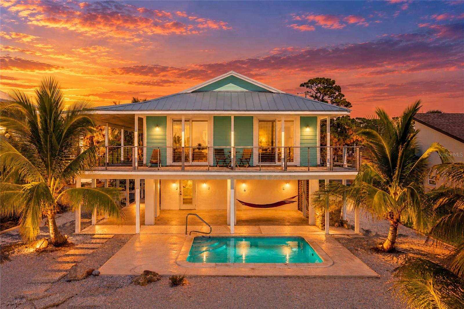 LIVING IN PARADISE ON LEMON BAY! Experience the beauty of Florida waterfront living in this exceptional, updated 2-bedroom, 2-bath home, where breathtaking panoramic views of Lemon Bay create a spectacular backdrop for everyday life. Imagine waking up to the sun sparkling across the water and ending each day with vibrant sunset colors reflecting across the bay. Soaring cathedral ceilings, expansive windows, and impact-resistant, hurricane-rated sliding glass doors invite natural light inside while opening to an upper deck and a separate screened-in deck, perfect for enjoying refreshing coastal breezes and unforgettable waterfront views. The property showcases numerous high-end renovations and quality upgrades, including Brazilian hardwood, exquisite Ipe and Tigerwood decking, stairs and louvers, and premium 316-grade stainless-steel cable railings. Additional improvements include a new tankless water heater, an elevated air-conditioning unit, new pool equipment, and updated outlets, switches, ceiling fans, lighting, garage door openers, and service doors throughout the two-car garage, utility room, and covered ground-level lanai areas. The open kitchen features warm wood cabinetry, granite countertops, a spacious center island, and stainless-steel appliances, creating an inviting space for entertaining and everyday living. Updated bathrooms, diagonal-set porcelain tile flooring throughout, and a convenient indoor laundry room add to the home's appeal. Beneath the elevated living area, an inviting in-ground pool offers the perfect place to cool off, soak up the Florida sunshine, and enjoy the laid-back coastal lifestyle. Even better, you're just a golf cart ride or an easy trip away from historic Dearborn Street in downtown Englewood, where charming restaurants, inviting coffee shops, a popular Farmers Market, and lively entertainment await. Combining spectacular Lemon Bay views, distinctive architectural details, extensive upgrades, exceptional outdoor living spaces, and a desirable location, this remarkable property offers a rare opportunity to enjoy the waterfront lifestyle you've been dreaming of!