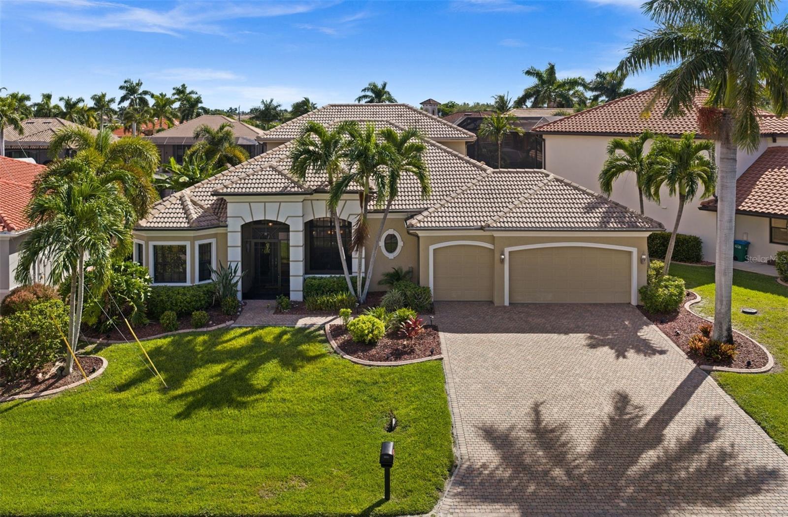 CUSTOM GULF ACCESS LIVING WITH ROOM TO SPREAD OUT. JUST A SHORT WALK TO CAPE HARBOUR! Built by Arthur Rutenberg Homes, this impressive two-story waterfront home offers 3,283 square feet with three spacious bedrooms, a den (currently used as a 4th bedroom), four full bathrooms, and a three-car garage in one of SW Cape Coral’s most desirable neighborhoods. From the generous living spaces to the extensive custom finishes, this home offers comfort, quality, and plenty of room for everyday living and entertaining. Ten-foot ceilings, eight-foot solid-core doors, decorative tray and coffered ceilings, crown molding, and tile and hardwood flooring add character throughout the spacious great room floor plan. Formal and casual dining areas provide room for everything from quiet breakfasts to holiday gatherings. The kitchen features custom wood cabinetry, granite countertops, a gas cooktop, tile backsplash, a center island, breakfast bar, and walk-in pantry. The primary suite overlooks the water through a beautiful bay window and offers direct access to the lanai and pool. Its spacious bathroom includes dual sinks, a makeup vanity, a separate tub, and a walk-in shower. Both guest bedrooms have their own bathrooms and walk-in closets, providing comfortable accommodations and privacy for family and visitors. The den, currently used as a fourth bedroom, adds flexibility, while the upstairs game or media room opens to a screened balcony overlooking the waterfront. Outside, the heated pool and spa, expansive paver deck, retractable awnings, and lush tropical landscaping create an inviting setting for hosting friends or relaxing in the Florida sunshine. A composite wraparound dock with a covered boat lift puts Gulf access boating right in your backyard. Additional features include impact-resistant windows and doors, a tile roof, remote-controlled blinds, central vacuum, ventilated wood closet shelving, a 250-gallon buried propane tank, generator prewiring, and a laundry room with a sink and extensive storage. Green Home certification and a paver driveway complete this thoughtfully appointed property. Enjoy the space and privacy of a custom waterfront home with Cape Harbour’s restaurants just a short walk away!