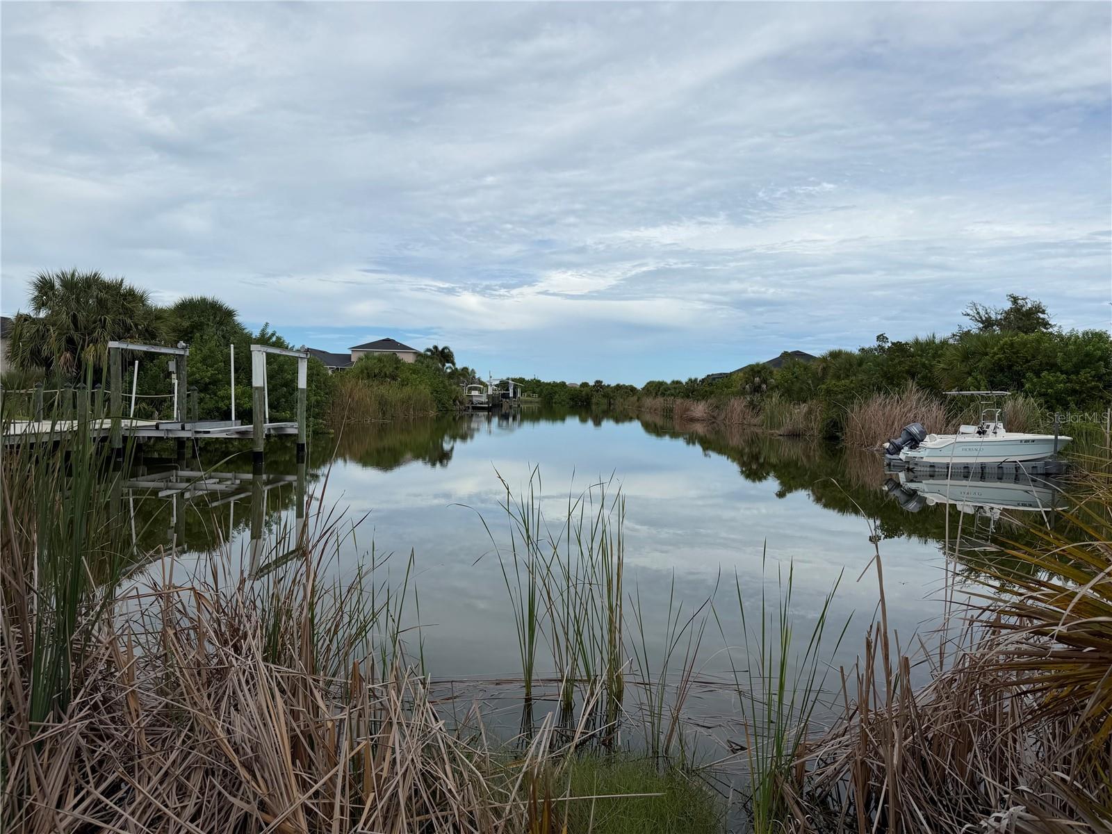 Sailboat water access with no bridges to open water.  These two lots combined are almost .5 acres.  Build a house in the center to maximize the sunset views over the canal, build two houses, use one for a detached garage, or purchase this along with the large house next door where you can move right in and have all of these options open in the future.  These lots have 100 feet of frontage at the end of the canal that heads directly west.