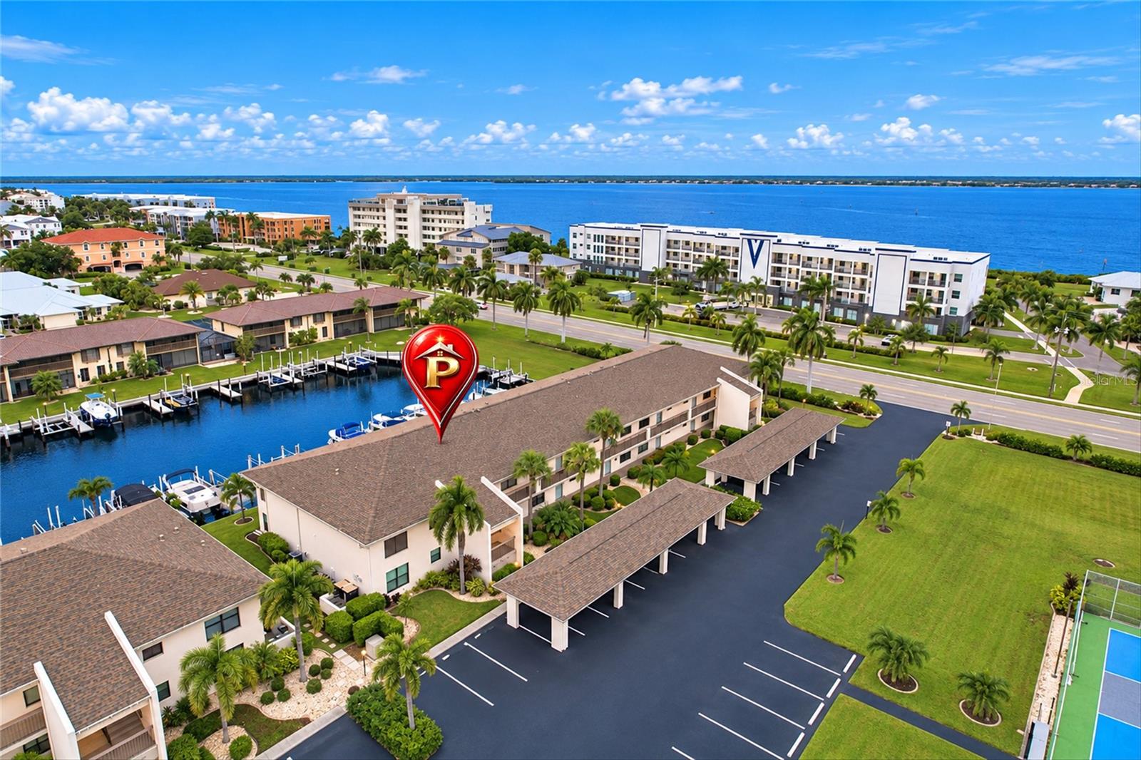 TURNKEY FURNISHED WATERFRONT CONDO WITH A DEEDED DOCK AND BOAT LIFT IN PUNTA GORDA ISLES! Discover the Florida lifestyle in this beautifully maintained FIRST-FLOOR, 2-BEDROOM, 2-BATHROOM CONDO located in the desirable BRIDGE POINT II COMMUNITY! Offering picturesque canal views, exceptional boating convenience, and an inviting interior, this residence is ready for you to move right in and enjoy everything Southwest Florida has to offer. Step inside to a BRIGHT AND OPEN FLOOR PLAN featuring TILE FLOORING THROUGHOUT, NEUTRAL TONES, and coastal-inspired furnishings. The spacious living and dining areas flow seamlessly together, creating a comfortable setting for everyday living and entertaining. The UPDATED KITCHEN features a TRAY CEILING WITH CROWN MOLDING, RECESSED LIGHTING, WARM WOOD CABINETRY, NEUTRAL-TONED COUNTERTOPS, STAINLESS STEEL APPLIANCES, a built-in wine rack, and a convenient BREAKFAST BAR overlooking the main living area. Decorative pendant lighting enhances the adjoining dining space, while the living room features a tropical-style ceiling fan and sliding glass doors opening to the screened lanai. The thoughtfully designed SPLIT-BEDROOM FLOOR PLAN provides privacy for owners and guests. The PRIMARY SUITE features DIRECT LANAI ACCESS, CANAL VIEWS, A WALK-IN CLOSET, and an updated en-suite bathroom with a beautifully tiled WALK-IN SHOWER. The guest bedroom is located on the opposite side of the residence near the second full bathroom, which includes a tub/shower combination. An INTERIOR LAUNDRY ROOM WITH FULL-SIZE WASHER AND DRYER adds convenience. Enjoy your morning coffee or unwind at sunset on the PRIVATE SCREENED LANAI, overlooking the tranquil canal and lush tropical landscaping. Boating enthusiasts will appreciate the 20' X 7' CONCRETE DOCK WITH A 10,000-LB. BOAT LIFT, electric and water at site. Enjoy QUICK BOATING ACCESS WITH JUST ONE BRIDGE TO CHARLOTTE HARBOR AND ONWARD TO THE GULF OF MEXICO, making it easy to spend your days cruising, fishing, or exploring the beautiful waterways of Southwest Florida. Additional features include HURRICANE PROTECTION THROUGHOUT and an ASSIGNED COVERED PARKING SPACE just steps from the front entrance. Residents of BRIDGE POINT II enjoy excellent community amenities, including a LARGE HEATED SWIMMING POOL, TENNIS AND PICKLEBALL COURTS, POOLSIDE DECK WITH BARBECUE GRILLS, RESTROOM FACILITIES, BICYCLE RACKS, and a designated vehicle washing area. The community is also PET-FRIENDLY, subject to association restrictions. Ideally situated in the heart of PUNTA GORDA ISLES, this condo is just minutes from FISHERMEN'S VILLAGE, GILCHRIST PARK, THE VISUAL ARTS CENTER, local marinas, walking and biking paths, and historic downtown Punta Gorda, offering waterfront dining, boutique shopping, entertainment, and year-round events. Whether you're searching for a SEASONAL GETAWAY OR FULL-TIME RESIDENCE, this move-in-ready waterfront condo offers an exceptional opportunity to embrace the relaxed Florida lifestyle. PACK YOUR BAGS AND START ENJOYING PARADISE!