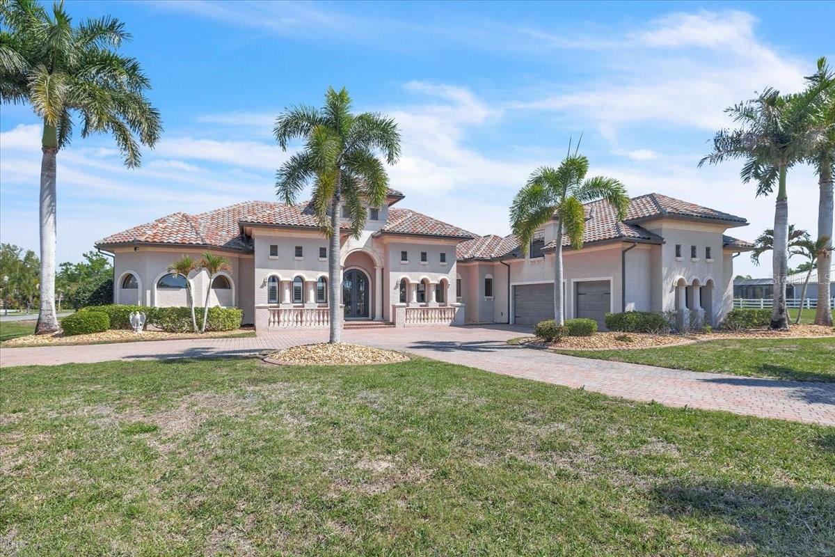 Welcome to this stunning custom residence, where timeless architecture meets the relaxed elegance of Florida living. Perfectly framed by
towering palm trees and a sweeping brick paver driveway, this home makes an unforgettable first impression with its grand façade, arched
entryway, and beautifully manicured landscaping. Architectural details shine throughout, from stately columns and decorative balustrades to the tile roof and refined exterior finishes that reflect a Mediterranean-inspired design. An oversized driveway and multiple garage bays provide ample space for guests and storage, while the lush surroundings create a private, estate-like setting. Situated within the exclusive, private gated enclave of The Estates on the Peace River, this extraordinary waterfront estate offers over 4,400 square feet of luxurious living on more than an acre, showcasing endless views of the Peace River and protected preserves. This custom-built, two-story Mediterranean masterpiece features 4 spacious bedrooms, 4.5 baths, a dedicated office, formal living and dining rooms, and a laundry room on the main level, with an upstairs fourth bedroom and full bathroom that can also serve as a media or game room. Exquisitely crafted, the home boasts soaring 16- to 20-foot coffered ceilings, 20-inch polished travertine flooring, 8-foot doors, solid wood cabinetry, granite countertops, stainless steel appliances, and a central vacuum system. The luxurious primary suite offers coffered ceilings, dual walk-in closets, and a spa-like bath complete with dual vanities, a jetted tub, and an expansive walk-through shower. Exceptional resort-style outdoor living awaits! This expansive screened lanai features a heated swimming pool with a built-in spa, offering the perfect blend of relaxation and year-round enjoyment. Designed for entertaining, the outdoor space includes ample lounging and seating areas set on elegant paver flooring, all protected by a full screen enclosure. The highlight is the tiki hut with a full kitchen, creating the ultimate outdoor entertaining and dining experience. Seamless indoor-outdoor flow and generous covered areas make this backyard a true private oasis—ideal for hosting gatherings or enjoying Florida’s outdoor lifestyle in comfort and style. Outdoors, the lush tropical landscaping is supported by a well-based irrigation system, while a three-car garage, brick paver motor court, and authentic clay tile roof complete this truly glamorous waterfront estate on the Peace River. Community amenities include boat ramp, boat slip for each home site, fishing pier, and tiki hut for casual get-togethers. For added opportunity and privacy, this property can also be combined with the adjacent Lot 20, available for an additional $150,000. **PLEASE ENJOY THE 3D INTERACTIVE VIRTUAL TOUR ASSOCIATED WITH THIS LISTING**