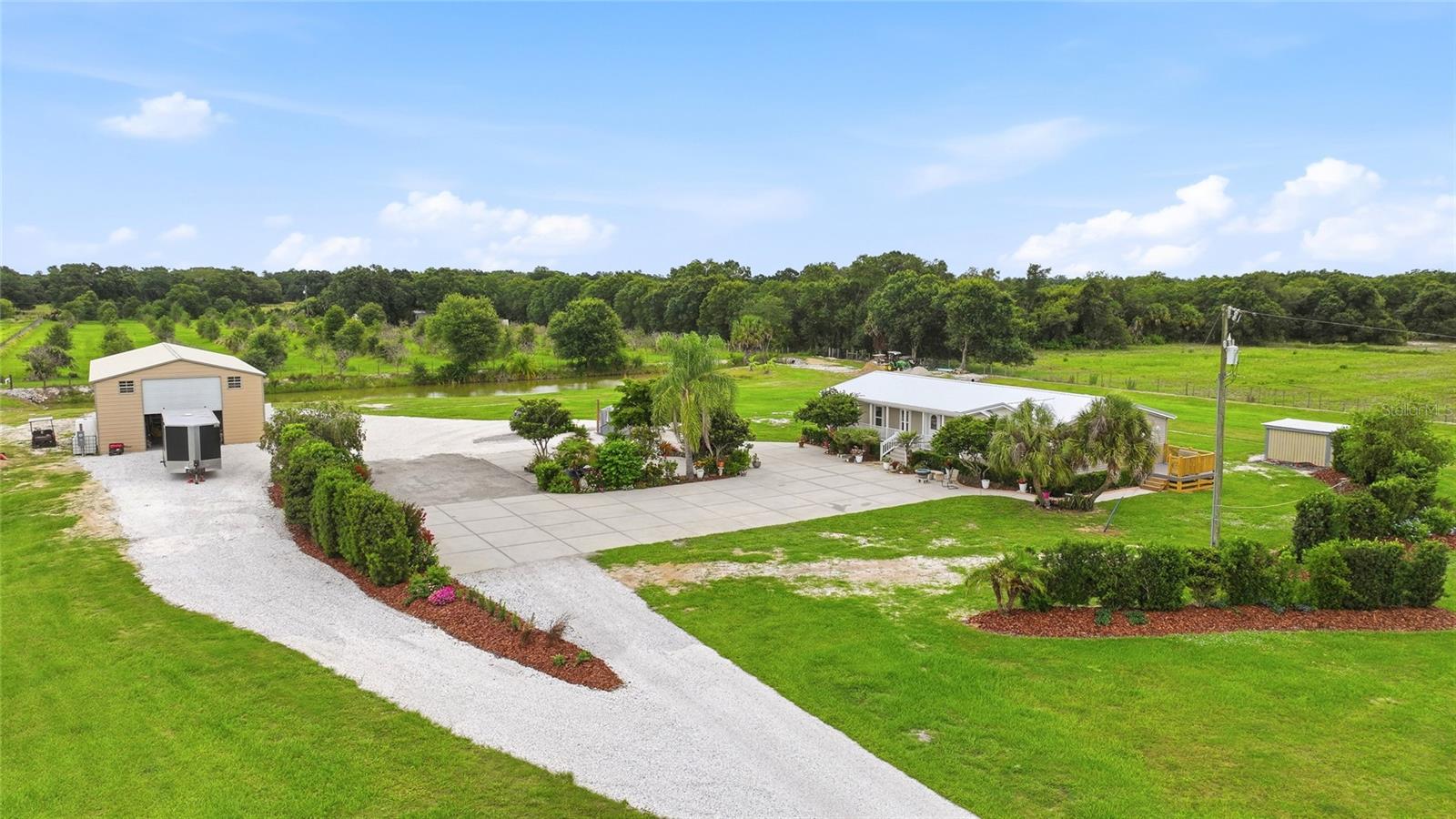 Welcome home to this stunning retreat where open skies, lush landscaping, and a working shop/barn create an extraordinary lifestyle — all just 10–15 minutes from the heart of Arcadia. From the moment you turn onto the long, sweeping circle driveway and pull onto the oversized concrete parking pad, you'll feel the difference. This is more than a property; it's a private world of your own. Climb the brand-new front porch stairs and step inside to discover a thoughtfully designed split and open floor plan flooded with natural light. Newer luxury vinyl plank flooring flows throughout much of the home, complemented by fresh interior paint that gives every room a crisp, move-in-ready feel. The kitchen is both functional and charming, featuring an inset stove and serene backyard views that make even everyday cooking feel like an event. The indoor laundry room, complete with a utility sink, adds everyday convenience, while a new side deck beckons you outside each evening to catch spectacular sunset views. And with a durable metal roof overhead, the big-ticket items are already taken care of Tucked away in its own wing, the generous primary suite is your personal sanctuary. The huge en-suite bathroom and oversized walk-in closet deliver the storage and comfort you deserve, and a versatile bonus area off the primary bedroom offers endless possibilities as a home office, cozy den, or dedicated home gym. The biggest bonus on this property may just be the massive barn and shop. Outfitted with three garage doors, a separate storage room, and tons of loft space, it is ready for whatever you can dream up, whether that is a workshop, hobby space, or business operation. It also features a fully equipped one-bedroom, one-bathroom apartment, opening the door to multi-generational living or rental income potential. A couple of additional storage sheds round out the outbuildings, giving you space for every tool and toy Step outside and breathe it all in. Spanning 4.7 fully fenced acres, the property is a tapestry of color and texture, with so many varieties of flowering plants and lush greenery that it feels like something out of a garden magazine. At the rear of the property, a tranquil pond sits perfectly positioned for quiet mornings, fishing, or simply soaking in the sounds of nature. Surrounded by open skies and the kind of peace that most only dream about, this land is a true private escape And yet, you are never far from what you need. In just 10 to 15 minutes, you are at the city limits of Arcadia, with easy access to grocery stores, restaurants, shopping, and schools. This is the rare property that gives you the best of both worlds, and opportunities like this do not come along often.