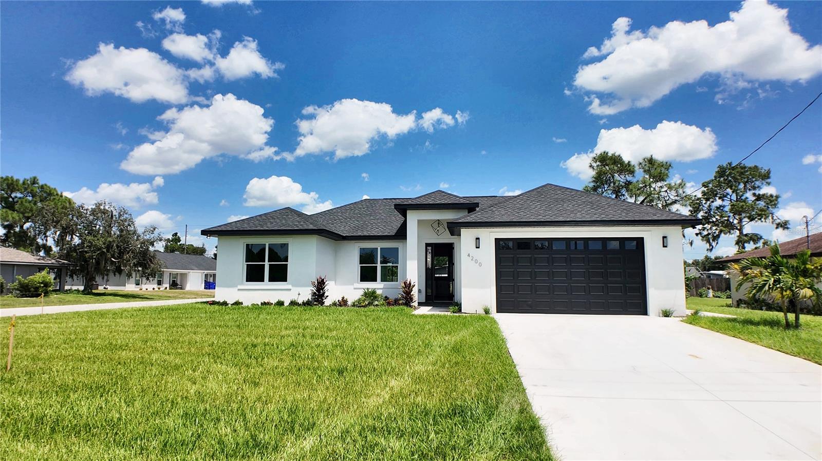 New construction, never occupied, on a corner lot in Orange Blossom Estates with no HOA and no CDD. The split floor plan gives you 3 bedrooms and 3 full baths in 1,505 square feet of living area, and bedroom 3 has its own private full bath. An eight foot front door with sidelight opens to vaulted ceilings in the living room and kitchen, with luxury vinyl plank flooring, granite windowsills, and vinyl double pane windows throughout. The kitchen has wood cabinets, granite counters, an island, a tile backsplash, and a stainless steel range, dishwasher, microwave, and refrigerator. The primary suite has a walk-in closet and a bath with dual sinks, granite, a walk-in shower, and a separate water closet. Bedroom ceilings run close to 10 feet, and every bedroom has a ceiling fan. All three baths carry the same tile, flooring, and granite, with tubs and showers tiled to the ceiling. Inside laundry room with a utility sink. Out back, a covered porch sits under the main roofline, and an irrigation well with pump and sprinkler system takes care of the lawn. Open front porch, a side walkway to the garage door, and a 2 car attached garage with opener. Concrete block and stucco with a shingle roof, central electric heat and air, central water, septic, and Duke Energy. Come walk it in person.