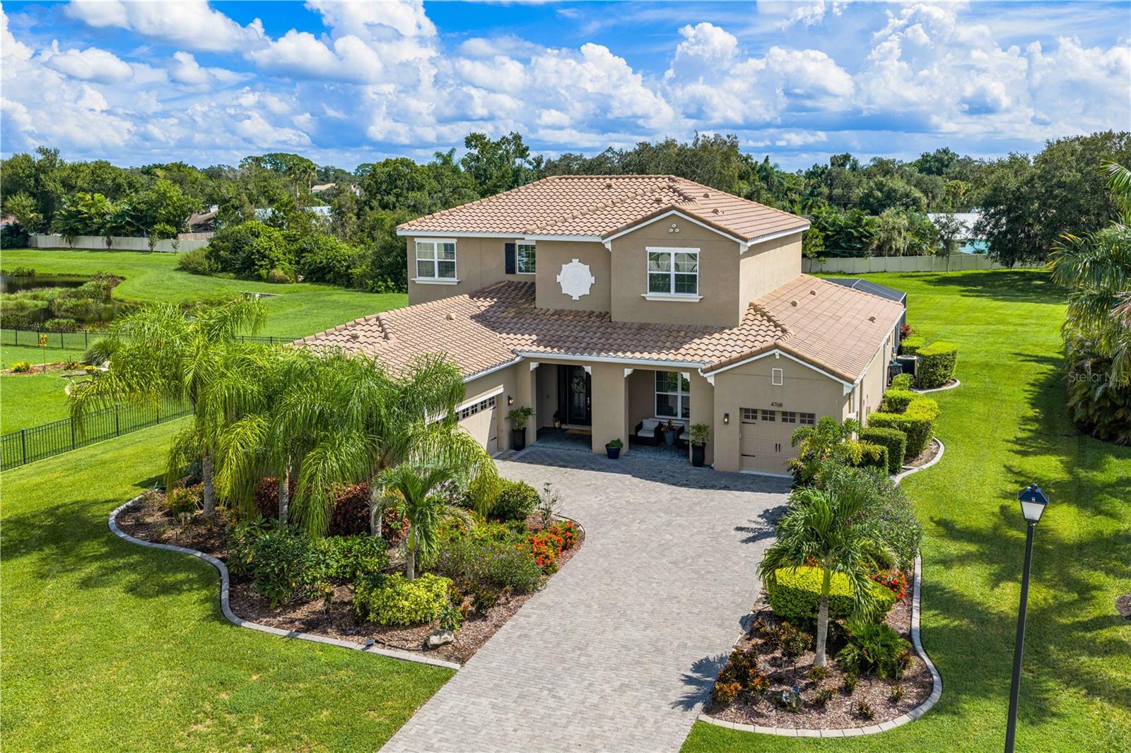 Welcome to Vilano, a distinctive Sarasota gated community offering newer construction and homesites conveniently secluded from the noise of busy streets. You’ll fall in love at first sight with this stylishly finished home, offering over 4,000 square feet of refined living space, four bedrooms, an office, a bonus room, and four and a half bathrooms. The spacious design integrates modern living with a cozy layout. Set on a quiet cul-de-sac, this beautiful home offers a rare combination of privacy, water views, and a genuine ergonomically outdoor setting. Different from other area lots, this approximately 1.1-acre homesite provides plenty of level lawn and green space to enjoy. The exceptional outdoor living area features a gourmet summer kitchen, a large heated pool with screened enclosure and lighting, a paver deck, and plenty of room to gather and unwind. Whether you were playing with the kids, entertaining guests, or simply relaxing by the oversized pool, everyone will find a comfortable spot to enjoy. 
Enter through double glass doors into a great room with soaring tray ceilings, 12-by-24-inch tile, a feature wall, and a four-panel, fully pocketing sliding glass door that opens to the pool area. The upgraded chef’s kitchen features an island, stone countertops, a built-in oven, a coffee bar, and a spacious pantry. The primary suite offers pool access, an oversized closet, and a generous bathroom with a soaking tub and dual vanities.
 Heading too the second level on rich wood stairs, you’ll find guest rooms, ample storage, and a spacious bonus room with barn doors. Each room has private access to a bathroom, which includes two of the guest rooms sharing a classic Jack and Jill design. 
A unique three-car garage configuration was designed with a separate one-car stall, which provides an area to store a vehicle, golf cart, or provide a private gym area. 
This turn-key home is the whole package which is conveniently located near A rated schools, UTC shopping and dining, and just minutes from Siesta Key beaches. Schedule your private showing today!