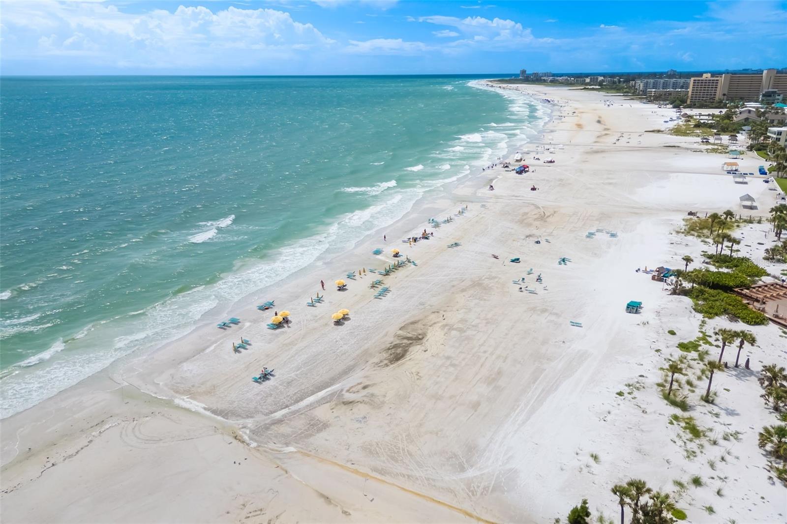 Picture your mornings starting with coffee on your screened lanai, a gulf view and soft sea breezes, then a few steps to the powdery white sand of world-famous Siesta Key beach. This 2-bedroom, 2-bath beachfront condo in a waterfront gated community is your own seasonal getaway when you want it and an established vacation rental when you don't. Weekly rentals are permitted, and the residence is already an active vacation rental with a proven booking history, so it can help offset the cost of ownership while you are away. Sold furnished and turnkey, it is ready to enjoy from the day you close. A split bedroom plan places a private en-suite bath with each bedroom, so guests and family each have their own retreat. Tile flooring throughout and a bright white kitchen with stainless appliances make for easy, low-maintenance coastal living. A large storage closet holds beach chairs, umbrellas and toys, and beach chairs are provided on the sand for owners and guests. Crescent Arms offers direct beach access, a community pool, tennis, an elevator and an assigned carport space, with a water view from the grounds and the Gulf just steps away. Stroll to nearby restaurants and shops, or hop on the free Siesta Key trolley to explore the island. A rare chance to own a piece of Siesta Key that works for you whether you are here or not.