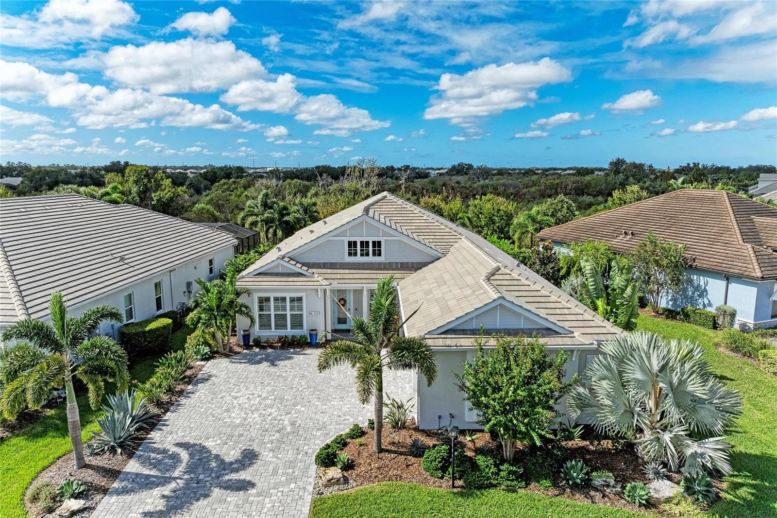 Welcome to luxury living in Lakehouse Cove at Waterside in Lakewood Ranch! This exquisite 3-bedroom plus office, 3-bathroom pool and spa home is situated moments from the vibrant heart of Waterside Place. Step through the front door into an open-concept layout defined by soaring ceilings, an elegant decorative accent wall, and expansive sliding glass doors that open directly to your private backyard oasis.

Out back, a peaceful preserve backdrop frames the heated saltwater pool and spillover spa, surrounded by an expansive paver deck. Designed for seamless indoor-outdoor entertaining, the covered lanai features a motorized sunshade and an outdoor grilling area complete with granite countertops, hood vent, and weather-resistant composite cabinetry.

Inside, the home delivers exceptional comfort and thoughtful design. The primary suite serves as a serene retreat featuring custom built-in closets. Two additional bedrooms include one with a private en-suite bath, while the dedicated home office is enclosed by glass French doors. The gourmet kitchen centers around a massive island with bar seating, complemented by a walk-in pantry and a separate coffee bar.

Additional upgrades include: Whole-house generator, Impact-rated windows and doors, Plantation shutters, Reverse osmosis water filtration under kitchen sink, Tankless gas water heater, Spacious 3-car garage with built-in storage, and Professional tropical landscaping. 

Lakehouse Cove offers true resort-style living with access to a community lakehouse with kayak launch and storage, pool and spa, fitness center, cabanas, fire pit, pickleball and bocce courts, event lawn, playground, two dog parks, and scenic nature trails with sunset lake views. Enjoy easy access to Waterside Place's dining, shops, weekly farmers market, splash park, and live entertainment—Conveniently located near UTC Mall, I-75, SRQ Airport, and Gulf Coast beaches.

Schedule your private showing today!