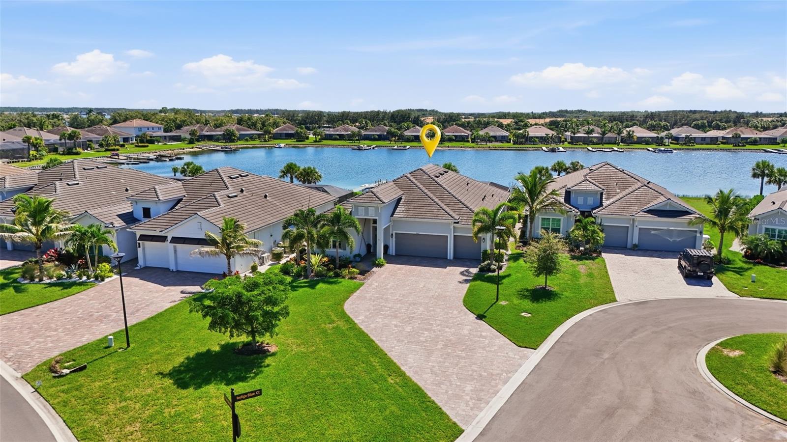 Discover the epitome of refined lakefront living in the prestigious, highly coveted community of Vista WildBlue. This exquisitely upgraded Richmond floor plan seamlessly blends elevated design, contemporary sophistication, and modern luxury with an exceptional outdoor living experience, creating a residence that is as elegant as it is inviting. Tucked back on a quiet cul-de-sac with sweeping water views, this turnkey furnished residence offers thoughtfully designed living space, including four bedrooms, a formal dining room/den, three full baths, and an oversized three-car garage. Make a stunning first impression with this beautifully appointed foyer, featuring soaring ceilings, an inviting neutral palette, and an impressive gallery-style hallway illuminated with striking fixtures. The long, open sightline leads to a light-filled living space, showcasing a striking outdoor space and panoramic water views beyond. Thoughtful design is enhanced by oversized tile flooring throughout, crown molding, designer lighting, and custom window treatments to create an inviting atmosphere. Step outside to discover your own waterfront retreat, where an expansive screened lanai with beautiful travertine decking creates the perfect setting for year-round Florida living. The fully equipped outdoor kitchen features an attractive stacked stone facade, built-in Blaze stainless grill and hood, refrigerator, stone top and storage. Take a refreshing dip in the gas-heated pool, relax on the sun shelf, or unwind in the spa while enjoying tranquil lake views through the panoramic picture-window screen. The chef's kitchen features abundant custom cabinetry with pull-outs, a sprawling island with sleek Silestone countertops, gas cooktop, and the added convenience of a butler's pantry and dedicated coffee bar. Whether hosting an elegant dinner in the formal dining room or enjoying a casual meal in the breakfast area overlooking the pool and lake, this versatile floor plan accommodates everyday living and entertaining with ease. The generously sized primary suite offers a spacious walk-in closet and convenient access to the adjoining laundry area. The spa-like bathroom features split vanities, garden bath, and rambling walk-in tiled shower. Three additional bedrooms and a separate den (or formal dining area) provide flexibility for a home office or additional living space. Beyond its beautiful finishes, this home is equipped with an impressive collection of practical upgrades, including a whole-home generator, hurricane-impact windows and doors, motorized storm screen, custom plantation shutters, motorized interior shades and custom draperies. Additional features include a Ring video doorbell and home security system, whole-home in-wall pest control system, and Moen Flo water leak detection technology. The lifestyle extends well beyond your front door in Vista WildBlue, where residents enjoy access to an extraordinary collection of resort-style amenities centered around an expansive 800-acre freshwater lake. Spend your days boating, fishing, or enjoying water sports, with a community boat ramp, marina, and private beach enhancing the waterfront experience. Additional amenities include a restaurant, state-of-the-art fitness and wellness center, pickleball, tennis, yoga, aerobics, and a full-service salon. The community also permits private dock installations at eligible homesites.