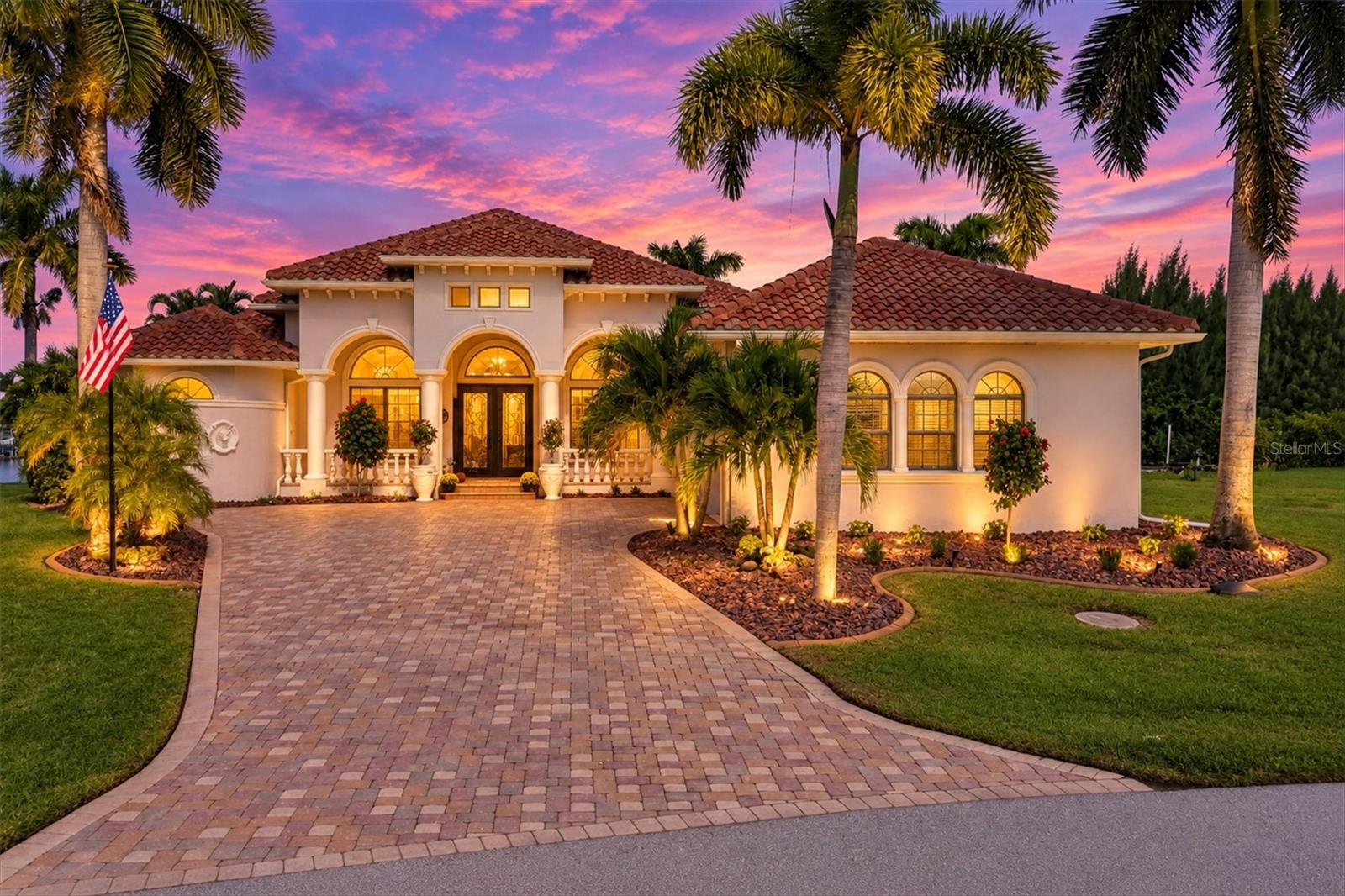 Discover an exceptional estate-style residence custom-built by Tim Towels and professionally designed with timeless elegance. Situated on a large TIPP lot, the property offers unobstructed waterway views extending to the expansive lagoon. This custom home features three bedrooms, three-and-a-half baths, a private office, a family room, and a bonus room.

The expansive living area features a gas fireplace and full-wall sliding doors that open to a European-inspired lanai. Designed for effortless entertainment, the outdoor space includes an infinity pool and spa that create the sensation of being at the water’s edge, a generous outdoor kitchen, a spacious entertainment area, and a fire pit with an integrated fountain, outdoor shower. Extensive lighting for nighttime show place. Inside, the European aesthetic continues in the professional chef’s kitchen, appointed with marble countertops, a Wolf gas range, professional-grade ventilation, a scenic tile backsplash, an illuminated coordinating ceiling treatment, a breakfast bar, and a dinette area.
Soaring cathedral and tray ceilings showcase custom-painted designs and original artwork—distinctive details that must be seen to be fully appreciated.

Additional highlights include versatile living spaces and an impressive formal dining room. The spacious primary suite features a luxurious bath with an oversized soaking tub with an etched glass wall and a walk-thru shower overlooking a professionally painted exterior wall that evokes the ambiance of an elegant European retreat and water views.

Completing the home are a spacious laundry room, an oversized three-car garage, and direct water access with a private boat dock and 15,000-pound lift—plus excellent fishing just beyond your back door. Freshly painted and enhanced with numerous upgrades, the property features a generator-ready hookup, new landscaping, a new roof installed in 2023, all-new irrigation wiring completed in 2026, and new hurricane-rated garage doors installed in 2023.New Hot water on demand. With distinctive custom details throughout, this remarkable waterfront residence must be seen to fully appreciate the exceptional features rarely found in a typical home.