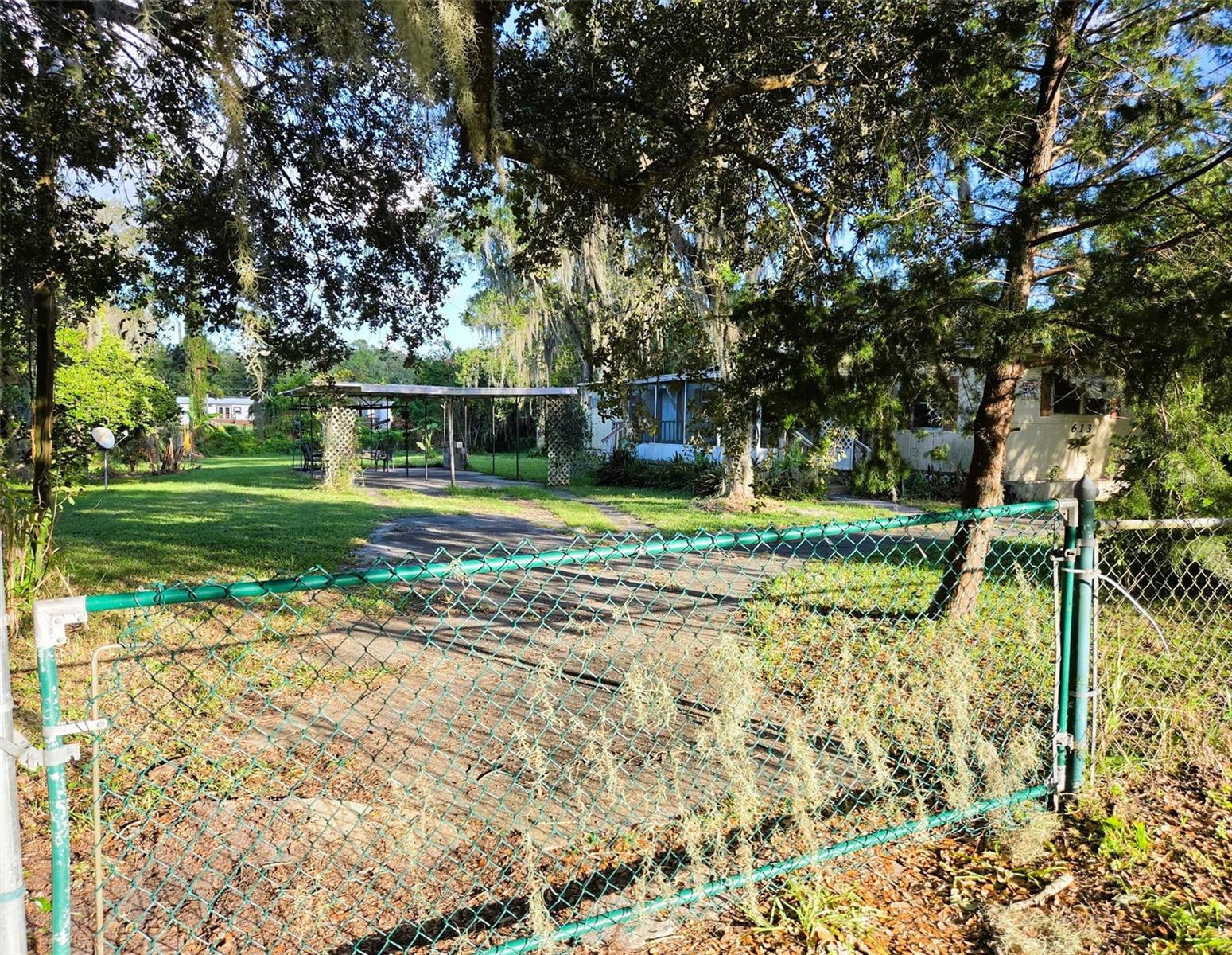 OPPORTUNITY AWAITS! 0.64 ACRES • NO HOA • GROWING EAST ORLANDO LOCATION! Bring your vision and unlock the possibilities! Situated on an expansive 0.64-acre (approximately 28,000 sq. ft.) fully fenced and gated lot, this property offers an exceptional blend of open space, privacy, and potential. Beautifully landscaped with majestic live oaks, there's plenty of room for boats, RVs, gardening, and outdoor enjoyment. Improvements include a 3-bedroom, 1.5-bath manufactured home, two-car carport, and two storage sheds. NO HOA OR LOT RENT! Located in the growing East Orlando/Bithlo area, just off Highway 50, with convenient access to SR 408, SR 417, UCF, Waterford Lakes shopping and dining, and approximately 45–60 minutes to Space Coast beaches. Ideal for investors, renovators, or buyers looking to create value and make this property their own. SOLD AS-IS! Buyer soley to verify zoning, permitted uses, measurements, and development possibilities. DON'T MISS THIS OPPORTUNITY!