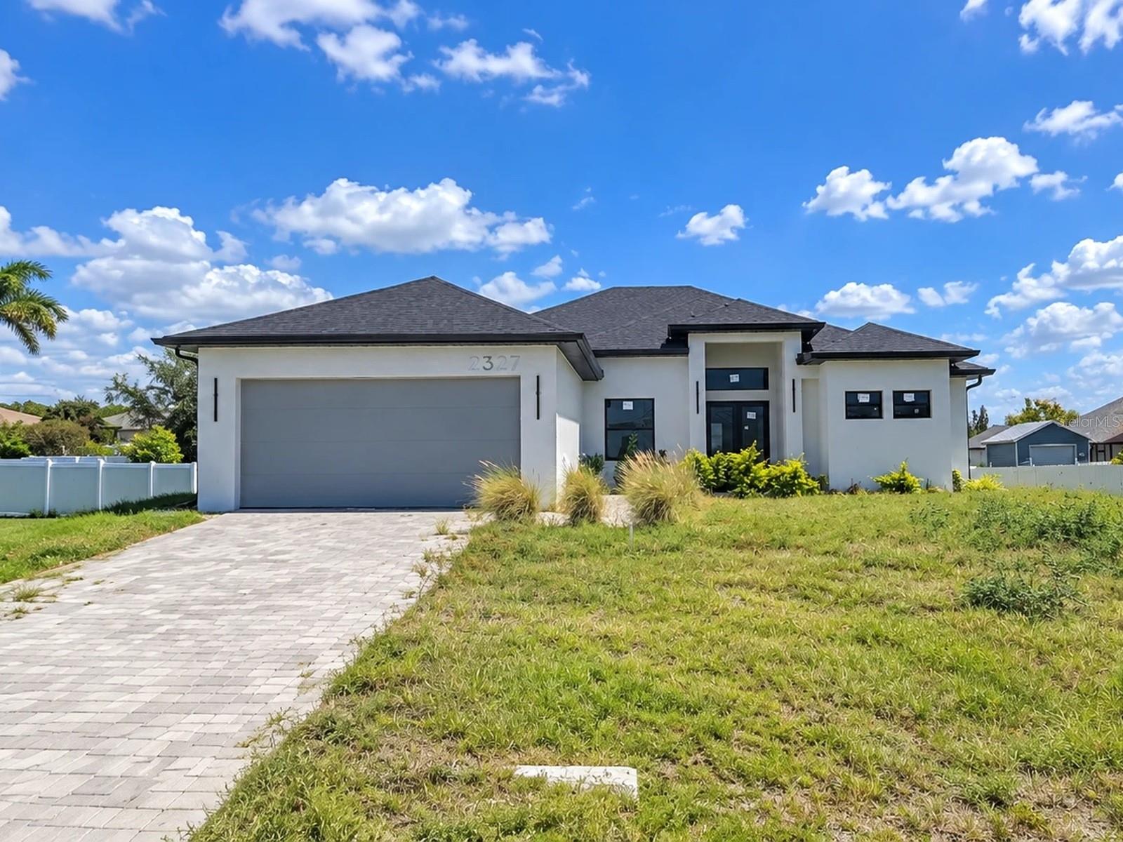 **CASH ONLY** HOME DOES NOT HAVE A CO (Certificate of Occupancy), BUYER MUST OBTAIN A CO POST CLOSING** Bank-owned opportunity to finish a nearly complete new construction pool home in NW Cape Coral with no HOA. This never-occupied 4-bedroom, 3-bath home offers 2,107 square feet of heated living space on a split-bedroom, open-concept plan, plus a 2-car attached garage on a 0.23-acre lot. The block and stucco structure, shingle roof, impact glass windows and doors, and screened pool enclosure are complete, and much of the interior is already in: white shaker cabinetry, a large waterfall center island with pendant lighting, marble-look tile throughout, tray ceilings, and ceiling fans. The primary bath has a frameless glass walk-in shower, and French doors open to the covered lanai and an in-ground pool with a sun shelf. Remaining work includes HVAC, appliances, electrical trim-out, pool equipment and cleanup, well and septic close-out, and final inspections. Minutes to Coral Oaks Golf Course, the Burnt Store boat ramp, and Pine Island Rd shopping and dining. Priced accordingly and sold As-Is by the REO seller. Cash offers only.