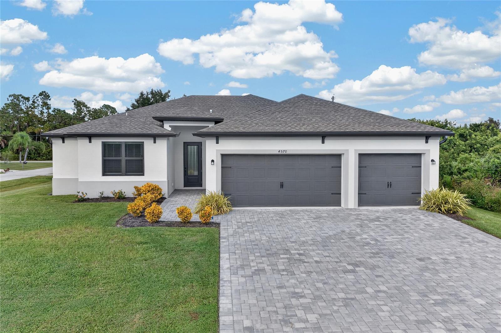 Virtually Staged. Discover the perfect combination of modern elegance, spacious living, and everyday convenience in this beautifully designed 5-BEDROOM, 2.5-BATHROOM, 3-CAR GARAGE HOME, perfectly situated on a desirable CORNER LOT in Port Charlotte! With its thoughtfully designed layout, inviting atmosphere, and stylish finishes, this home offers an exceptional opportunity to enjoy the best of Southwest Florida living.

Step through the IMPACT-RESISTANT FRONT DOOR into a bright and welcoming interior, where a neutral color palette and beautiful LUXURY VINYL PLANK FLOORING create a seamless blend of style and functionality. The spacious main living areas offer an inviting atmosphere with plenty of room to gather, entertain, and enjoy everyday life. The thoughtfully designed floor plan provides an effortless connection between the living room, dining area, and kitchen, making the heart of the home feel both open and welcoming.

The KITCHEN is designed with both beauty and practicality in mind, offering a functional layout that makes preparing meals and entertaining a breeze. A spacious WALK-IN PANTRY provides exceptional storage and organization, while the kitchen's connection to the surrounding living and dining spaces allows you to stay engaged with family and guests.

Designed to offer comfort and privacy, the PRIMARY SUITE serves as a relaxing retreat, featuring luxury vinyl plank flooring and an en-suite bathroom complete with a SEPARATE PRIVATE WATER CLOSET for added convenience. Four additional bedrooms offer comfortable accommodations with soft carpeting, providing versatile spaces for family, guests, or even a dedicated home office. An additional full bathroom and a conveniently located half bathroom add to the home's functionality, making it easy to accommodate both everyday routines and visiting guests.

Outside, the home's attractive exterior and CORNER LOT LOCATION create a wonderful first impression. A beautiful PAVER DRIVEWAY leads to the impressive 3-CAR GARAGE, offering abundant space for vehicles, storage, and recreational equipment. Gutters provide an additional practical feature, while the surrounding outdoor space offers exciting possibilities for creating your own personal Florida retreat.

Ideally located in Port Charlotte, this home provides convenient access to shopping, dining, entertainment, and everyday essentials. Enjoy nearby parks, recreational activities, boating opportunities, and the stunning Gulf Coast beaches of Englewood, all while embracing the relaxed lifestyle that makes Southwest Florida so desirable.

With FIVE SPACIOUS BEDROOMS, a THREE-CAR GARAGE, a desirable CORNER LOT, and a beautifully designed interior, this home offers the space, comfort, and versatility you've been searching for. Schedule your private showing today and discover everything this exceptional property has to offer!