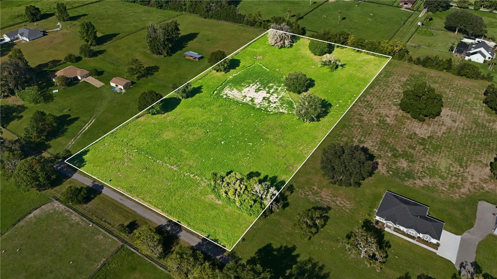 Discover the perfect balance of privacy, convenience, and equestrian living on this exceptional 5.70-acre homesite in Southeast Ocala. Zoned A-1, this property offers the flexibility to bring your horses and other animals while providing the ideal setting to build your custom dream home, barn, workshop, or private estate. The homesite will soon feature a newly paved asphalt driveway! A major advantage of this property is that much of the site preparation has already been completed. The land has been professionally cleared while thoughtfully preserving several beautiful, mature trees that provide character, natural shade, and a picturesque setting for your future home. Fill dirt has also already been brought in and leveled on-site, offering an excellent starting point for a potential house pad and helping reduce future site preparation costs. Location is where this property truly stands apart. Enjoy peaceful country living just 5 minutes from the Country Club of Ocala, 10 minutes from historic Downtown Ocala, and only 25 minutes from the World Equestrian Center—making it an outstanding opportunity for equestrian enthusiasts, trainers, and anyone seeking quick access to Ocala's world-renowned horse industry. A minimum 2,500-square-foot home requirement helps preserve the quality and value of the surrounding properties while still allowing the freedom to create the estate you've always envisioned. Whether you're dreaming of a luxury custom home with a show barn, a private family compound, or simply room to enjoy the outdoors, this property offers endless possibilities. Large acreage homesites in Southeast Ocala with this combination of privacy, convenience, and equestrian potential are becoming increasingly rare. Don't miss this opportunity to build your dream property in one of Ocala's most desirable locations.