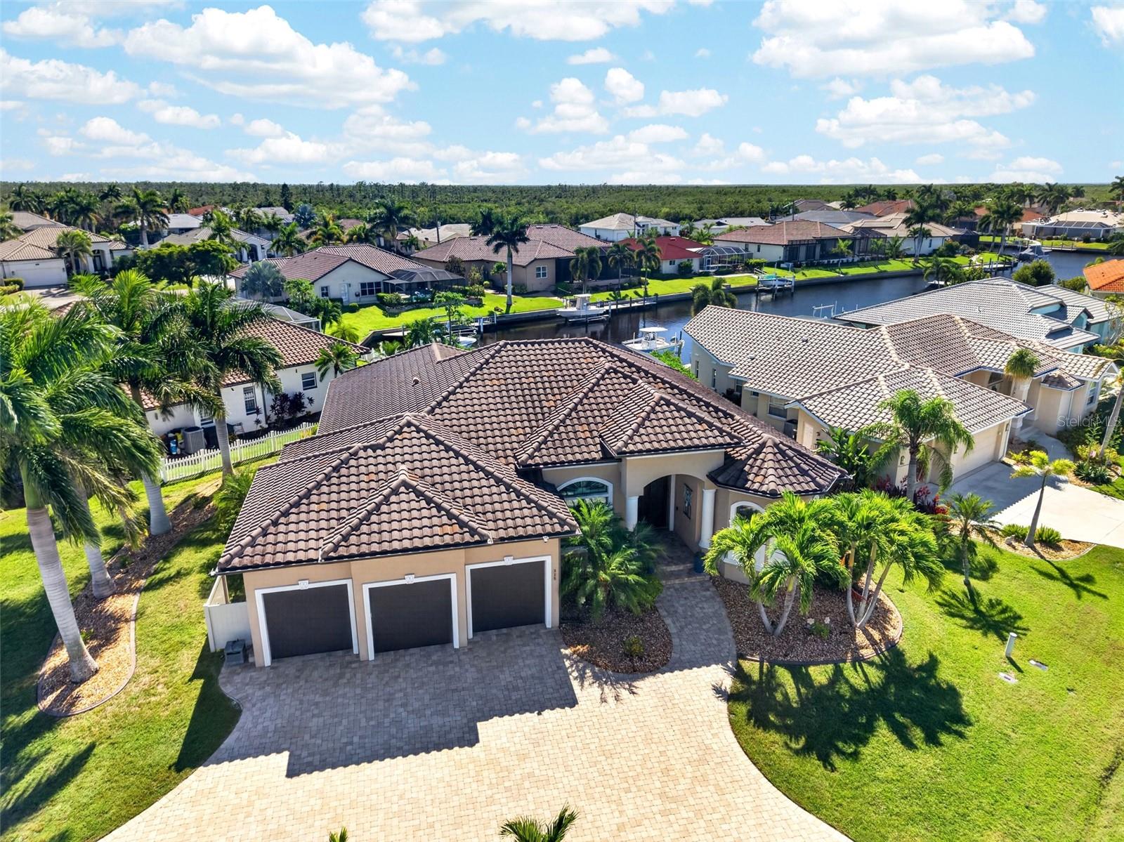 Burnt Store Isles! Waterfront boating lifestyle at its finest! Exceptional 3-bedroom plus  office, 2-bath, 3-car garage waterfront pool home on oversized corner lot with direct sailboat access and southwestern exposure to enjoy gorgeous sunsets.
Boaters will appreciate saltwater canal frontage with no fixed bridges via Alligator Creek to Charlotte Harbor leading to the Gulf. The concrete dock features 10,000 lb. boatlift with new bunks, motors, and a GEM control panel in 2024. The waterfront setting is beautifully complemented by a heated saltwater pool and freestanding heated spa, expansive screened lanai and two covered outdoor entertaining areas featuring tongue and groove ceiling, an outdoor kitchen with a built-in grill, exhaust fan, sink, hot water, and bar refrigerator plus a fully fenced backyard with exterior lighting and mature tropical landscaping.
Inside, the open-concept floor plan showcases soaring ceilings, double tray lighted ceiling, crown molding, plantation shutters, tile flooring and 8-foot zero-corner hurricane-impact sliding glass doors that open to the lanai, pool, and water views. The spacious kitchen is designed for entertaining with abundant solid-wood cabinetry, granite countertops, premium KitchenAid appliance package and large center island with breakfast bar. 
The spacious primary suite enjoys pool and waterfront views, a sitting area, two walk-in closets with 2025 Closets by Design custom systems and luxurious ensuite with dual vanities and a Roman-style walk-through shower. Two additional bedrooms offer built-in closets, while the separate office provides an ideal space for working from home.
Additional features include hurricane-impact windows, doors and sliders throughout, hurricane-rated garage door, whole-house surge protection, portable-generator transfer switch and 2025 Ecobee security system for ultimate peace of mind. The 3-car garage includes smart MyQ garage-door openers, while the circular paver driveway provides generous additional parking.
Great location in popular golf and boating community minutes from Twin Isles Country Club to enjoy golf, tennis, fine dining and many social activities and a short drive to the Yacht Club, Fishermen's Village, and historic downtown area of Punta Gorda. Enjoy access to arts, community events, entertainment, world-class fishing, boating and beautiful parks, as well as easy access to I-75. Thoughtfully enhanced throughout, this stunning Burnt Store Isles residence offers the perfect combination of boating, entertaining, privacy, and Florida waterfront living. Schedule your private showing today!