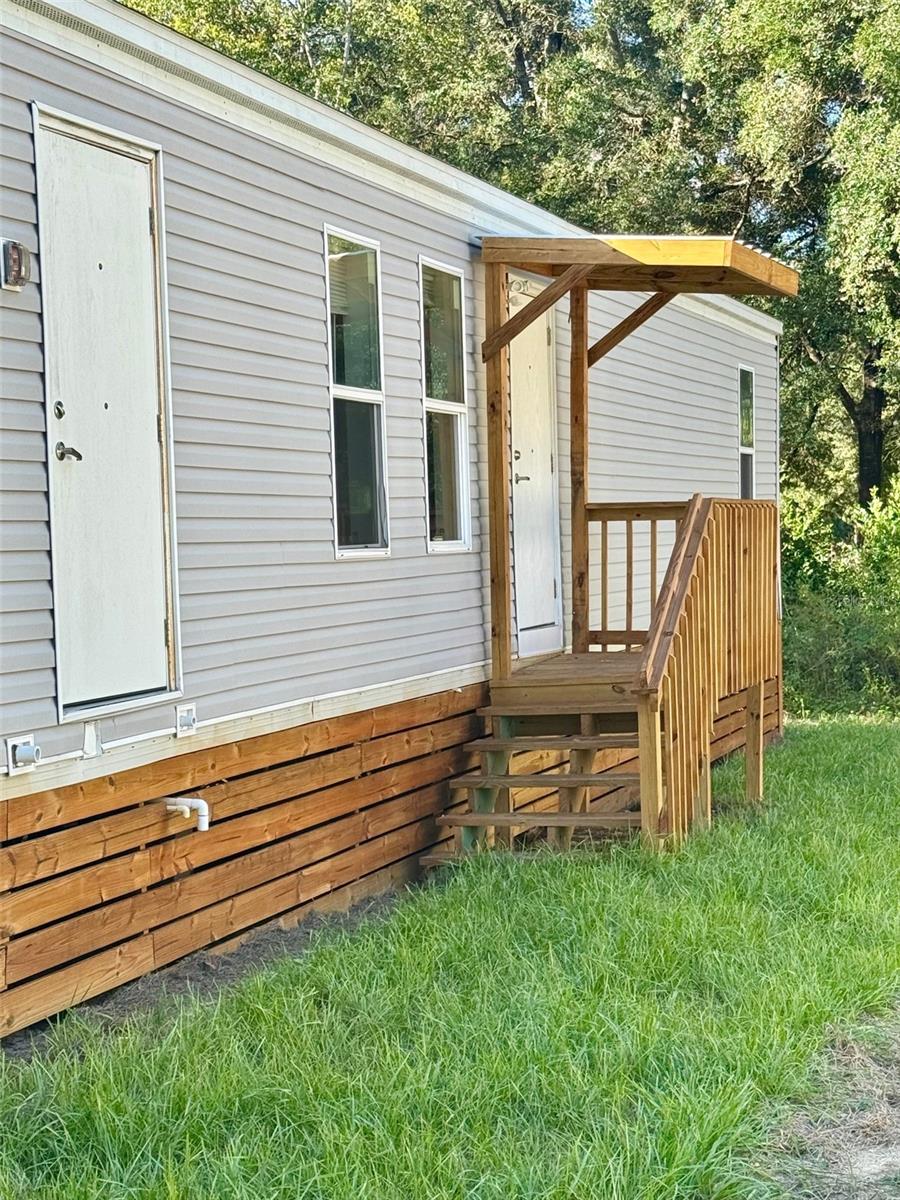 VA FINANCING NOW CONFIRMED — Modern 3BR/2BA Accessible Manufactured Home with Fire Suppression & Private Utilities — Move-In Ready! A rare opportunity just got even better — this upgraded and permanently installed 3-bedroom, 2-bath manufactured home is now FHA-eligible, making homeownership more accessible and affordable for qualified buyers. Located just outside Williston, minutes from the World Equestrian Center, Gainesville, and UF, this like-new property blends safety, efficiency, and long-term value in a peaceful country setting with NO HOA. Originally part of FEMA’s advanced-design housing program, this home offers far superior construction and safety features compared to typical mobile homes — including a full fire suppression sprinkler system, self-contained HVAC for cleaner air and simplified service, and true wheelchair accessibility with wide doorways and barrier-free design throughout.

Inside, the home features an open-concept layout, brand-new appliances including washer/dryer, upgraded finishes, and thoughtfully designed living spaces ready for immediate full-time use or long-term rental income. Outside, you'll find a fresh asphalt driveway, pressure-treated porches, and brand-new well and septic systems — all newly installed and permitted. 

Key Advantages:
NOW VA APPROVED — HUGE financing opportunity
Fully wheelchair accessible throughout
Integrated fire sprinkler system for added safety & insurance benefits
Self-contained HVAC system for low maintenance & improved indoor air quality
No HOA, low taxes, and flexible use potential — ideal for primary occupancy or rental portfolio
Minutes to WEC, Gainesville, UF, top hospitals & shopping
Homes like this — VA-eligible, safety-enhanced, no-HOA, country feel with city access — almost never hit the market.
Act quickly — rare VA-qualified second-set manufactured home with high-end safety and accessibility features won’t last. Seller open to, conventional portfolio, and possible owner financing.